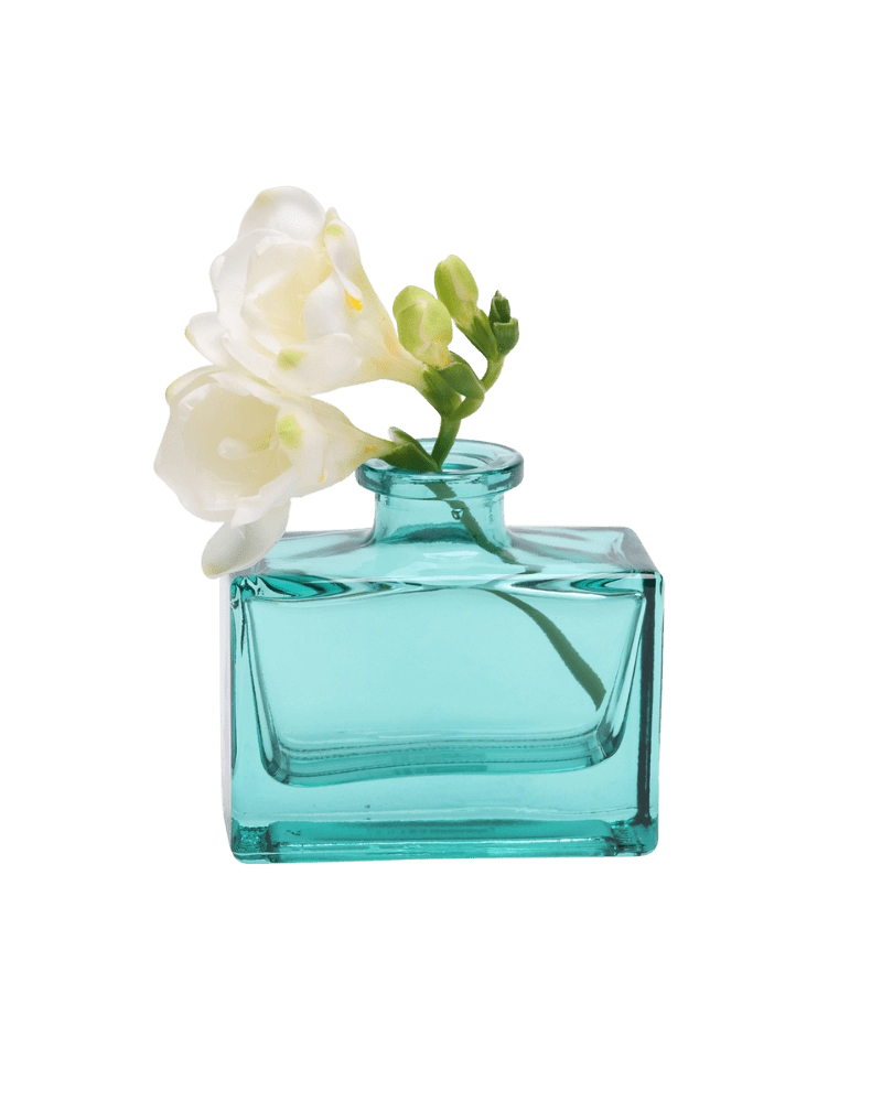 Chive Loft glass bud vase in Teal holds white freesia blooms with trailing green buds.