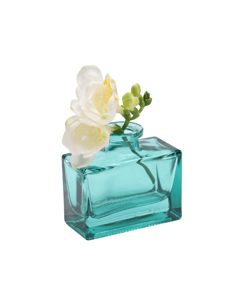 Chive Loft glass bud vase in Teal cradles white freesia at an angle, showing the jar's full shape.