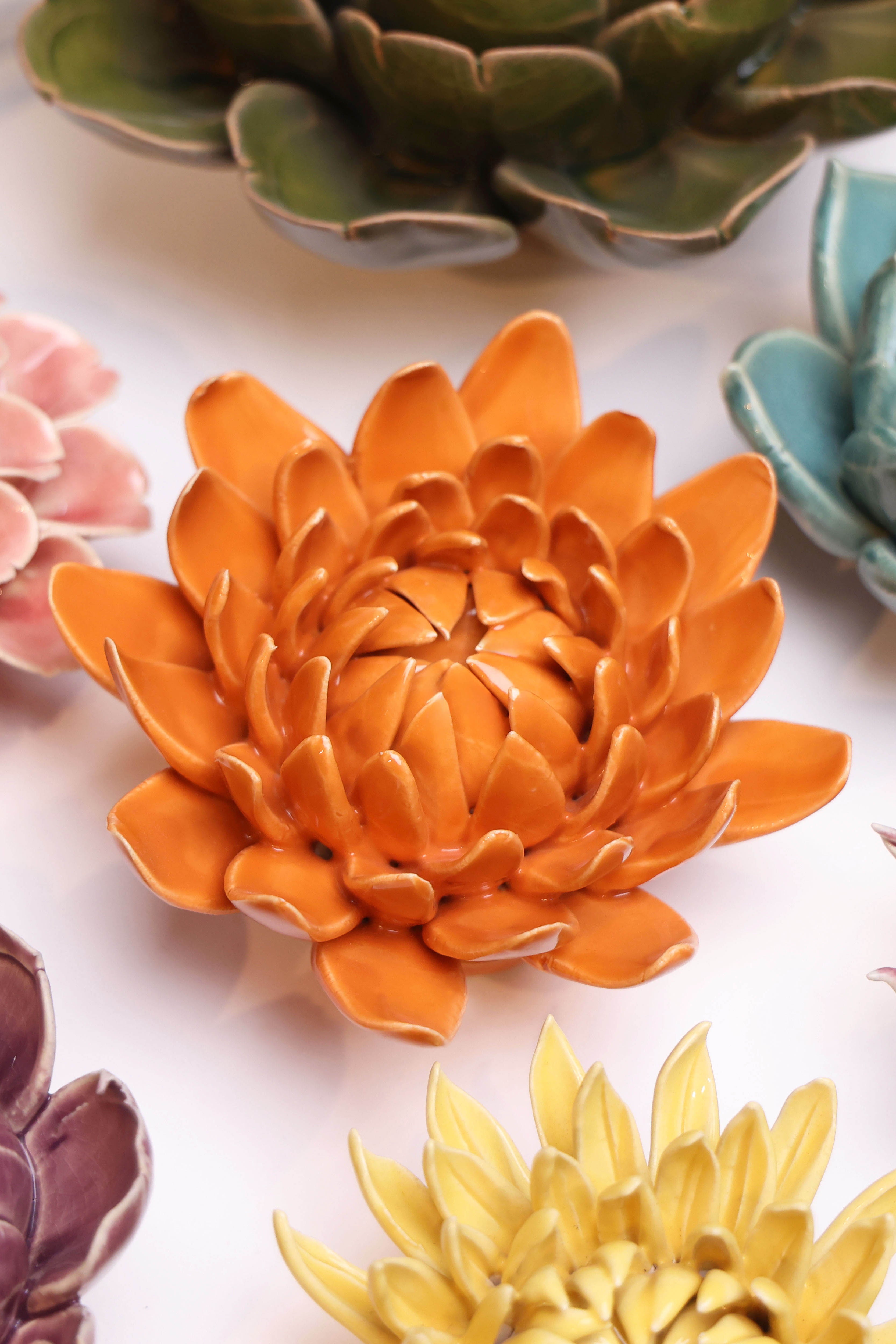 Dahlia Orange ceramic wall flower styled on wall — Classic Collection — Chive Studio Toronto