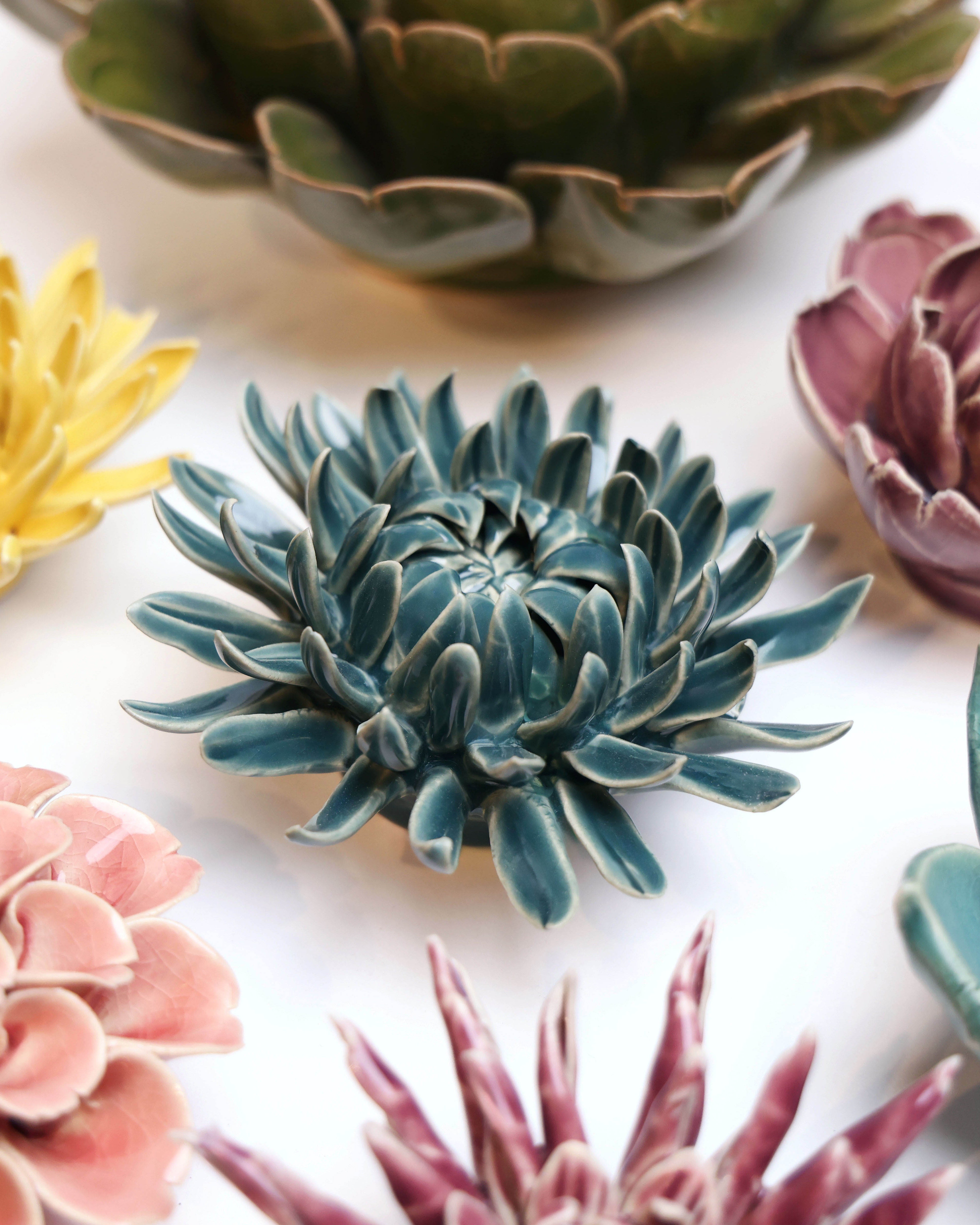 Mum Teal 11 ceramic wall flower styled on a white table with other flowers — Chive Studio