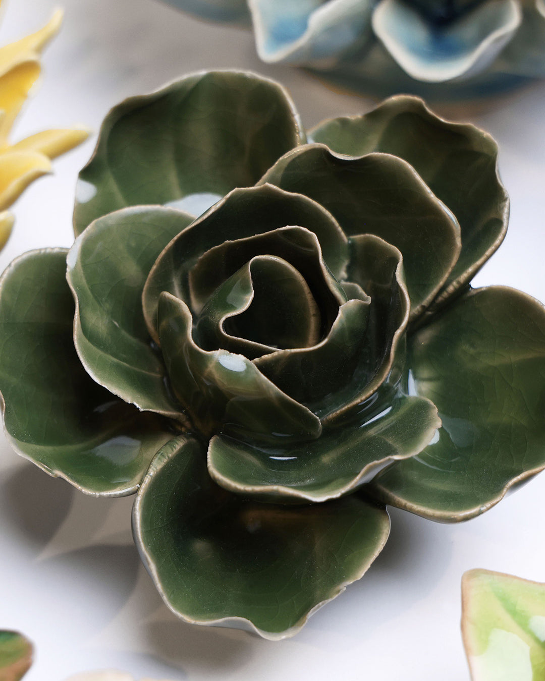 Fir Green Butterfly Ranunculus ceramic wall flower mounted on a wall — Chive Ceramics Studio