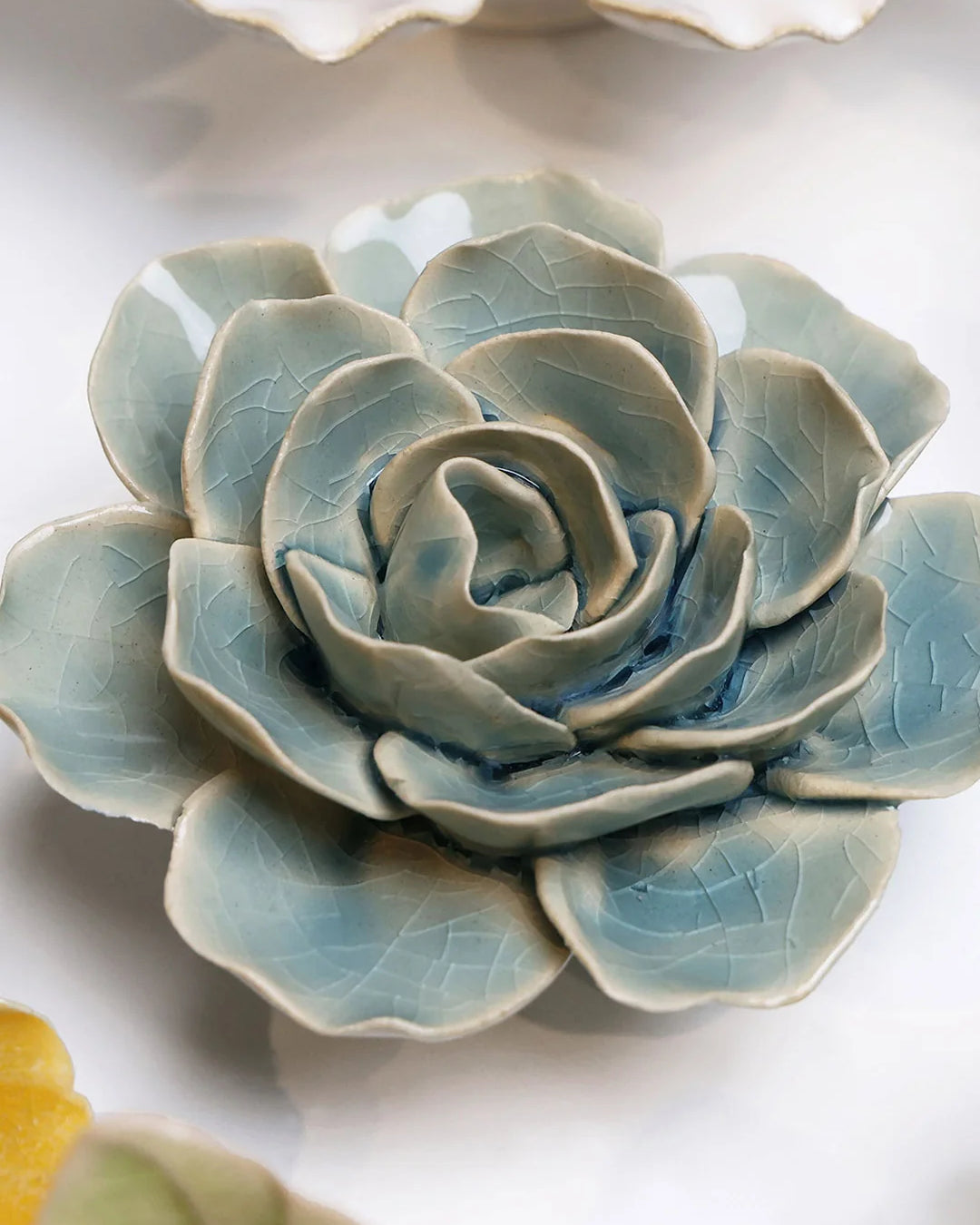 Powder Blue Amandine Ranunculus ceramic wall flower styled on a white table with other flowers — Chive Studio