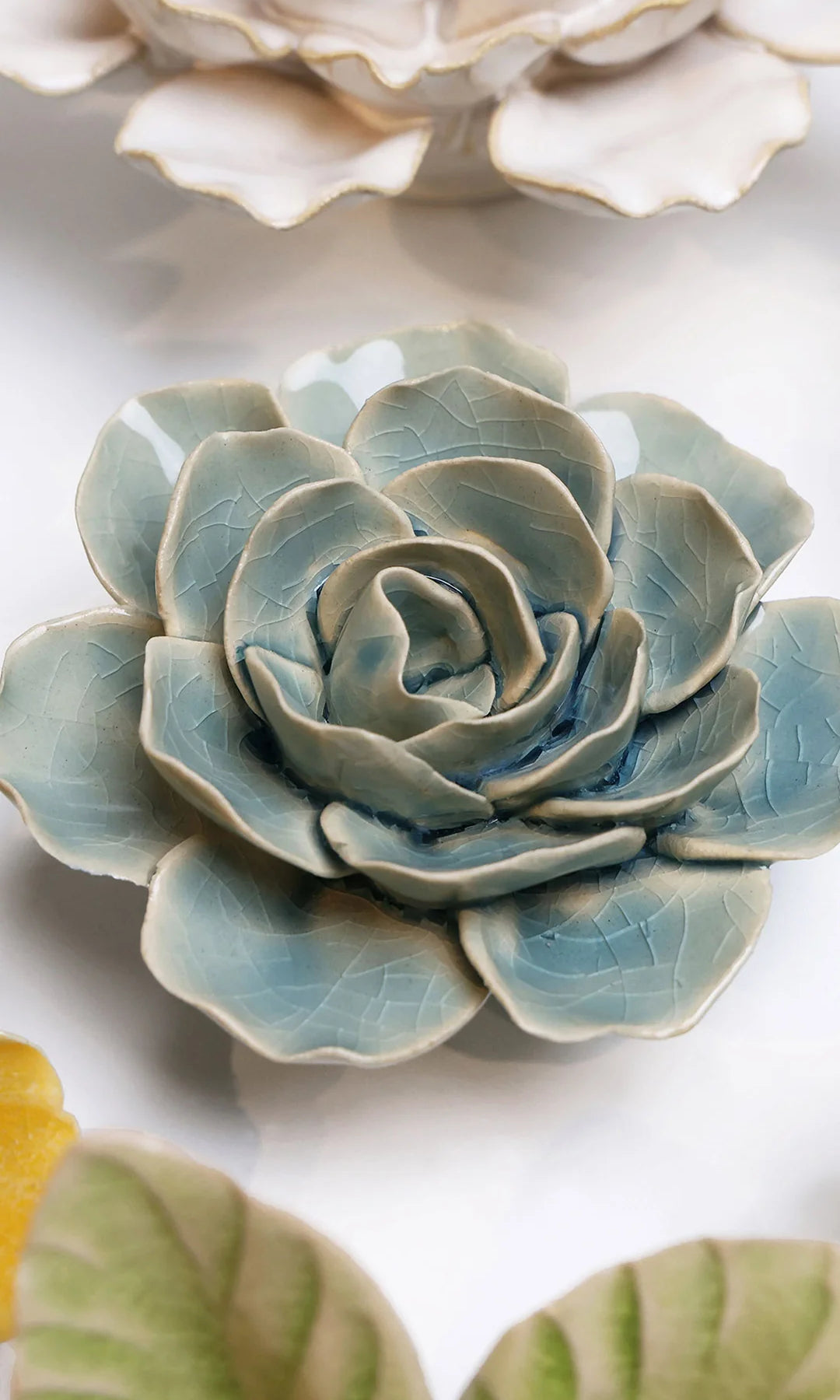 Powder Blue Amandine Ranunculus ceramic wall flower styled on a white table with other flowers — Chive Studio