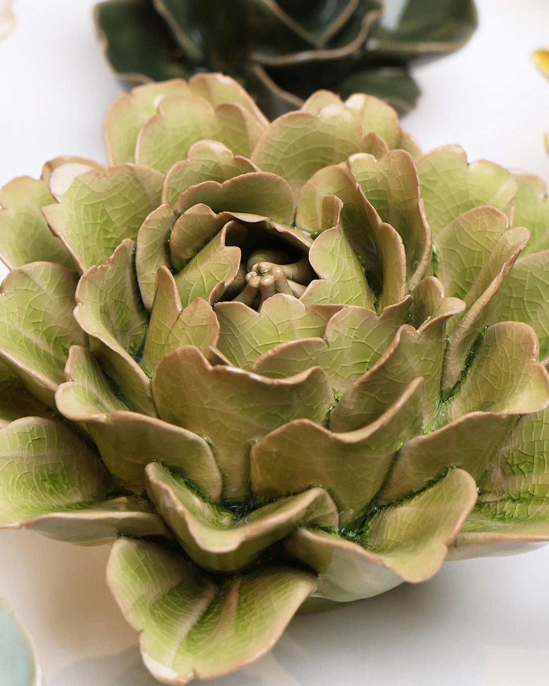 Peridot Peony ceramic wall flower styled on a white table with other flowers — Chive Studio