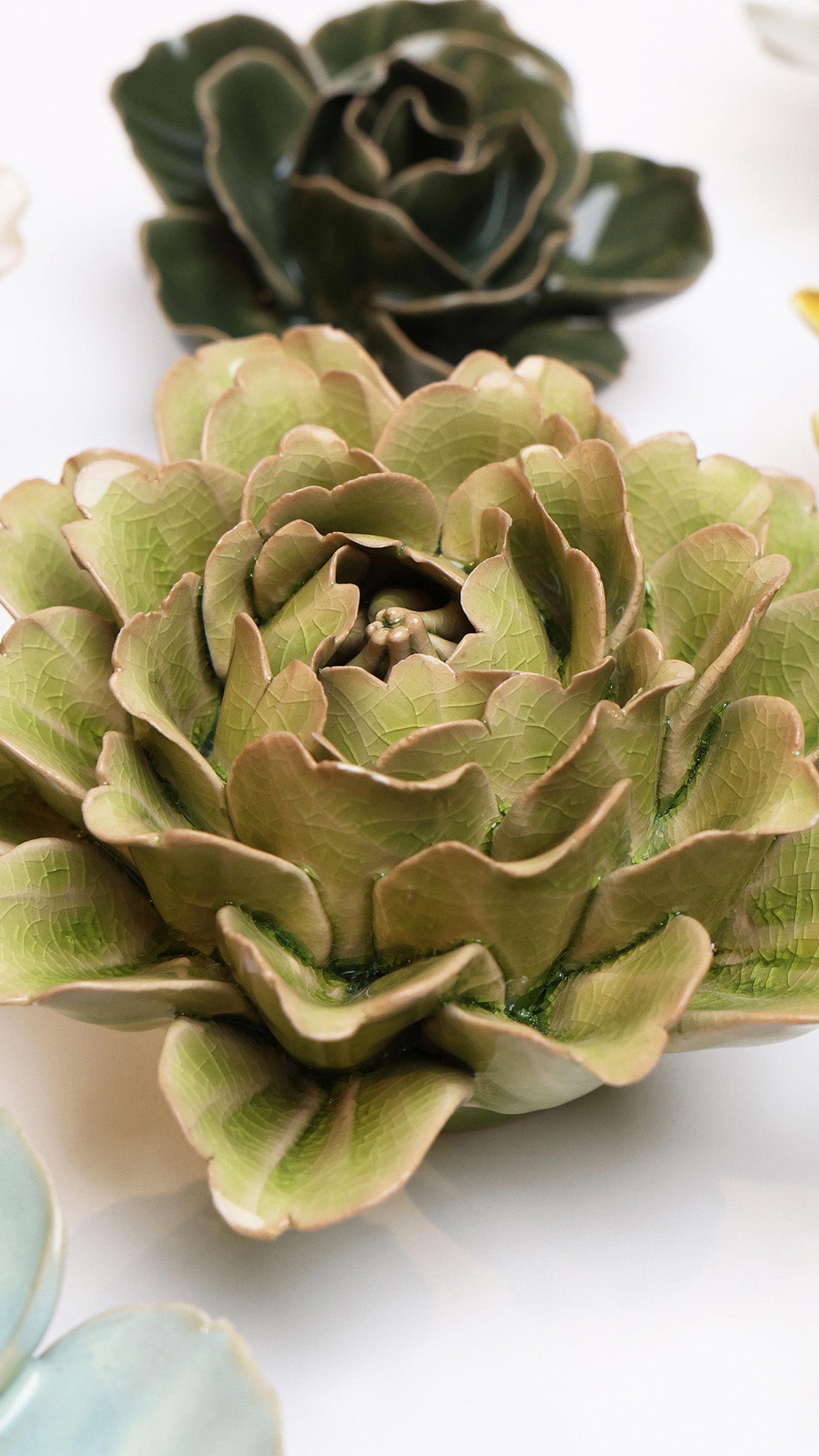 Peridot Peony ceramic wall flower styled on a white table with other flowers — Chive Studio