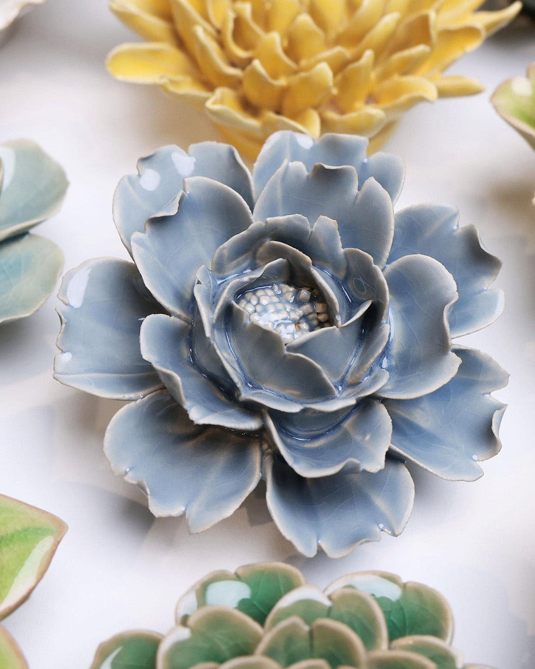 Pastel Blue Rose ceramic wall flower styled on a white table with other flowers — Chive Studio