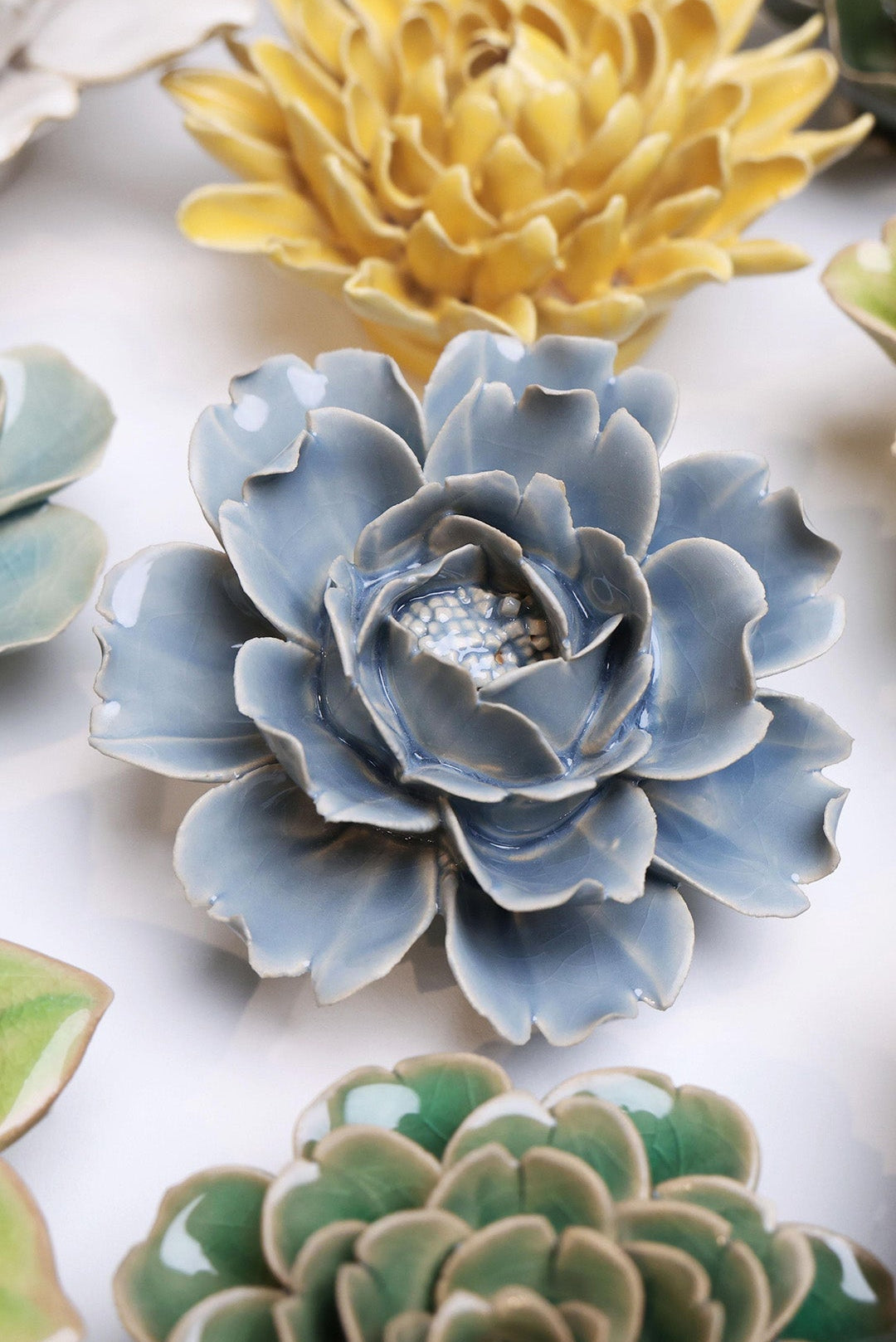 Pastel Blue Rose ceramic wall flower styled on a white table with other flowers — Chive Studio