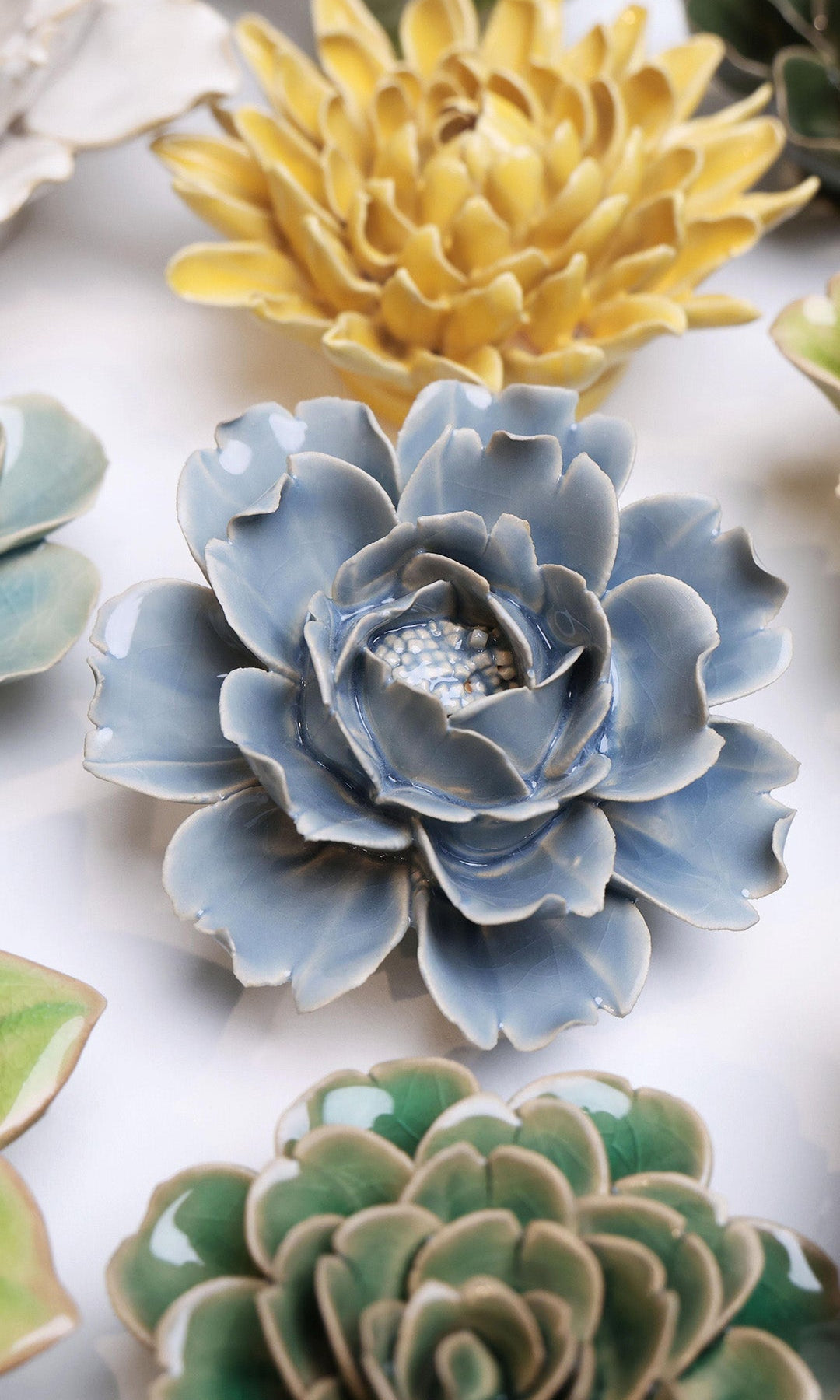 Pastel Blue Rose ceramic wall flower styled on a white table with other flowers — Chive Studio