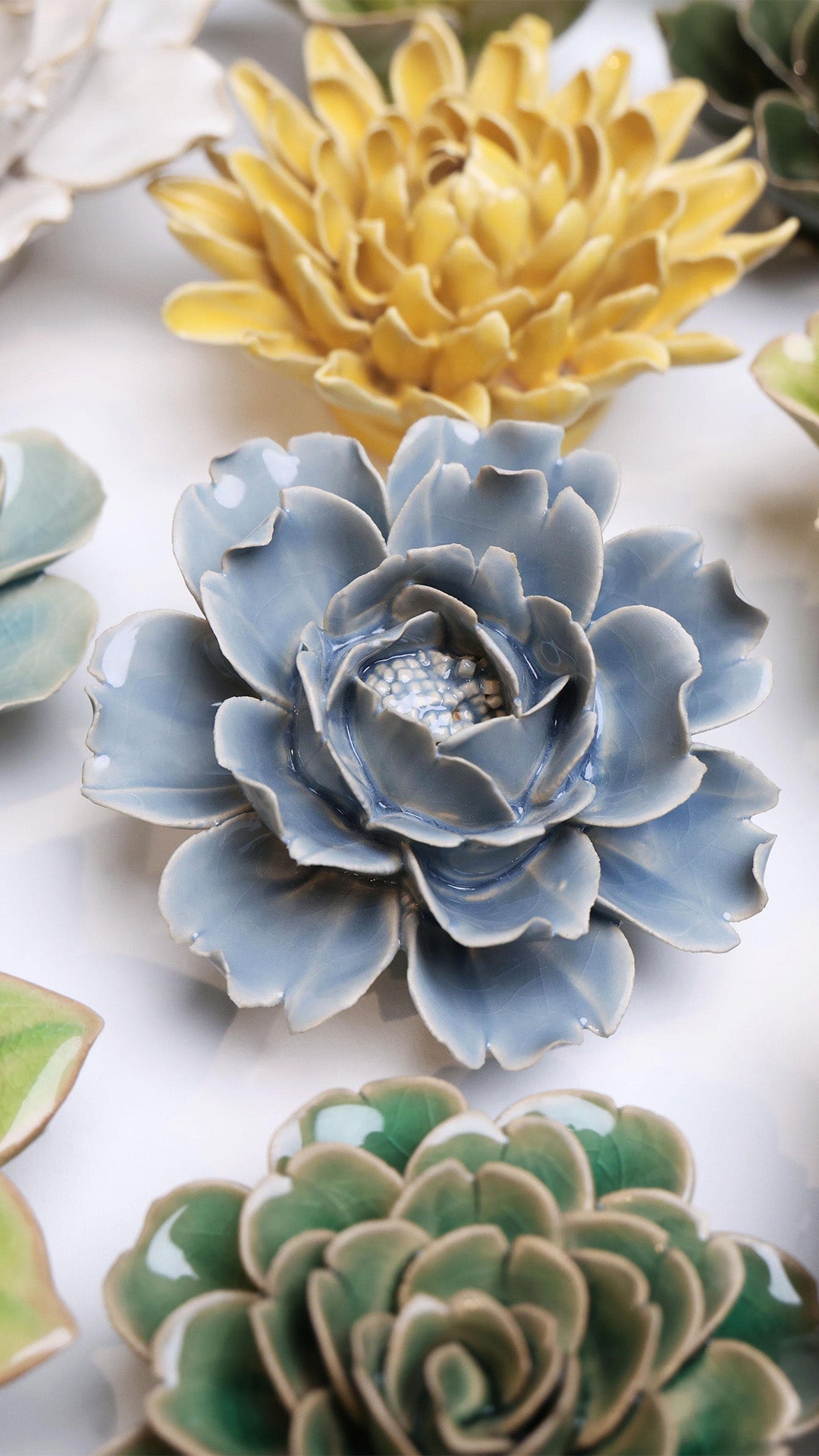 Pastel Blue Rose ceramic wall flower styled on a white table with other flowers — Chive Studio