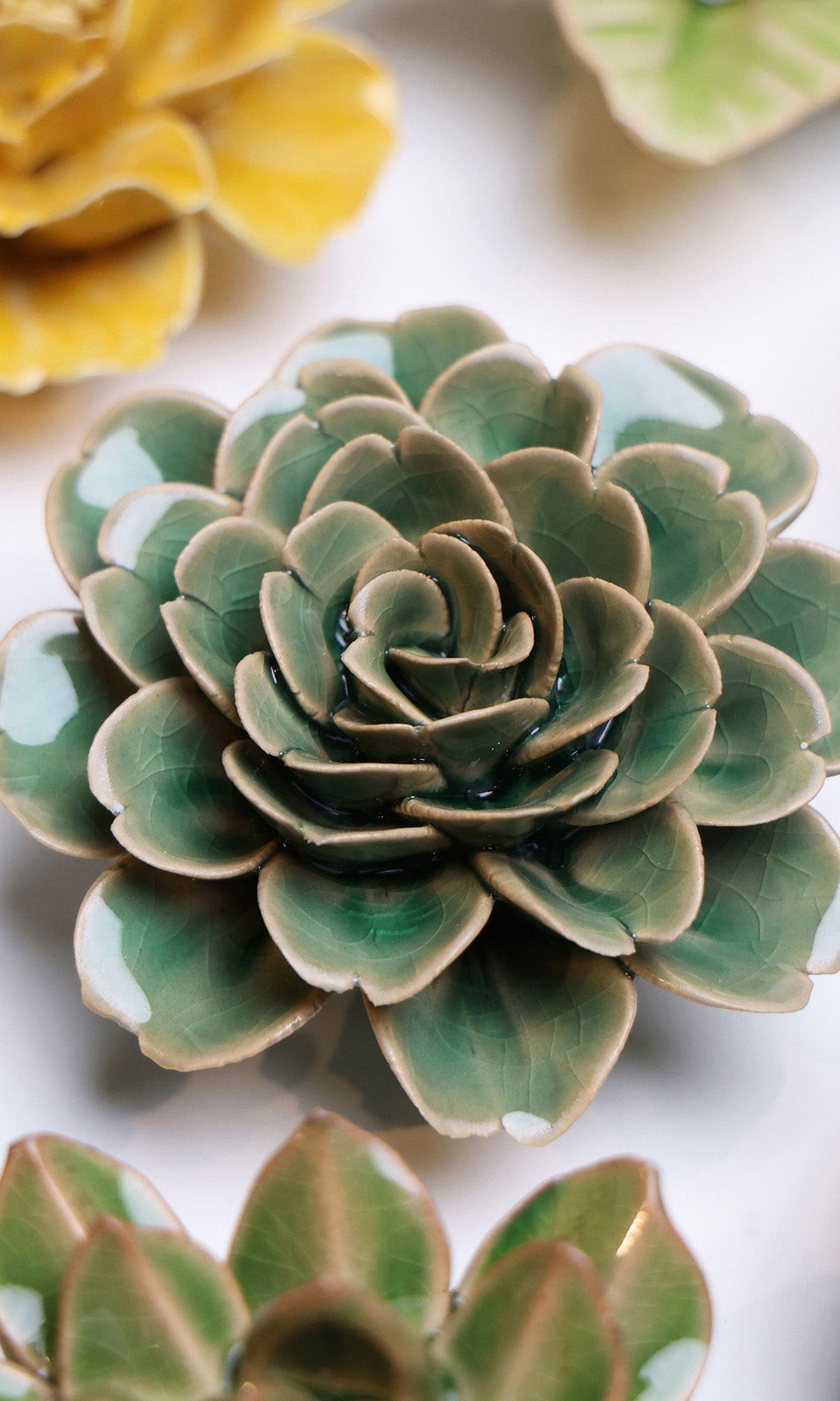 Jungle Green Rose ceramic wall flower styled on a white table with other flowers — Chive Studio