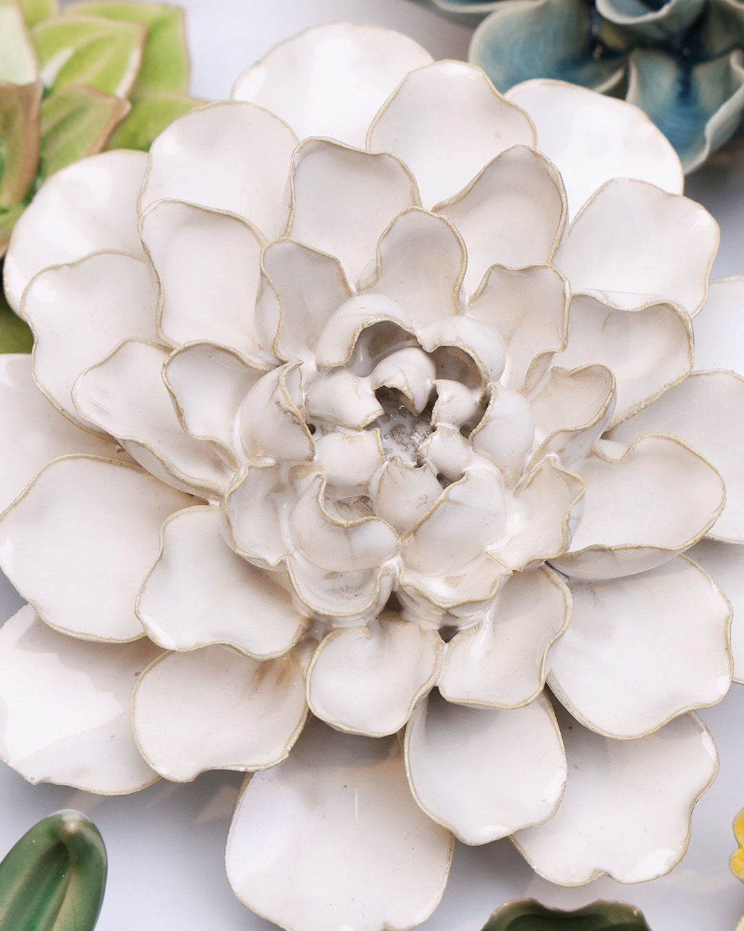 Ivory Water Lily ceramic wall flower styled on a white table with other flowers — Chive Studio