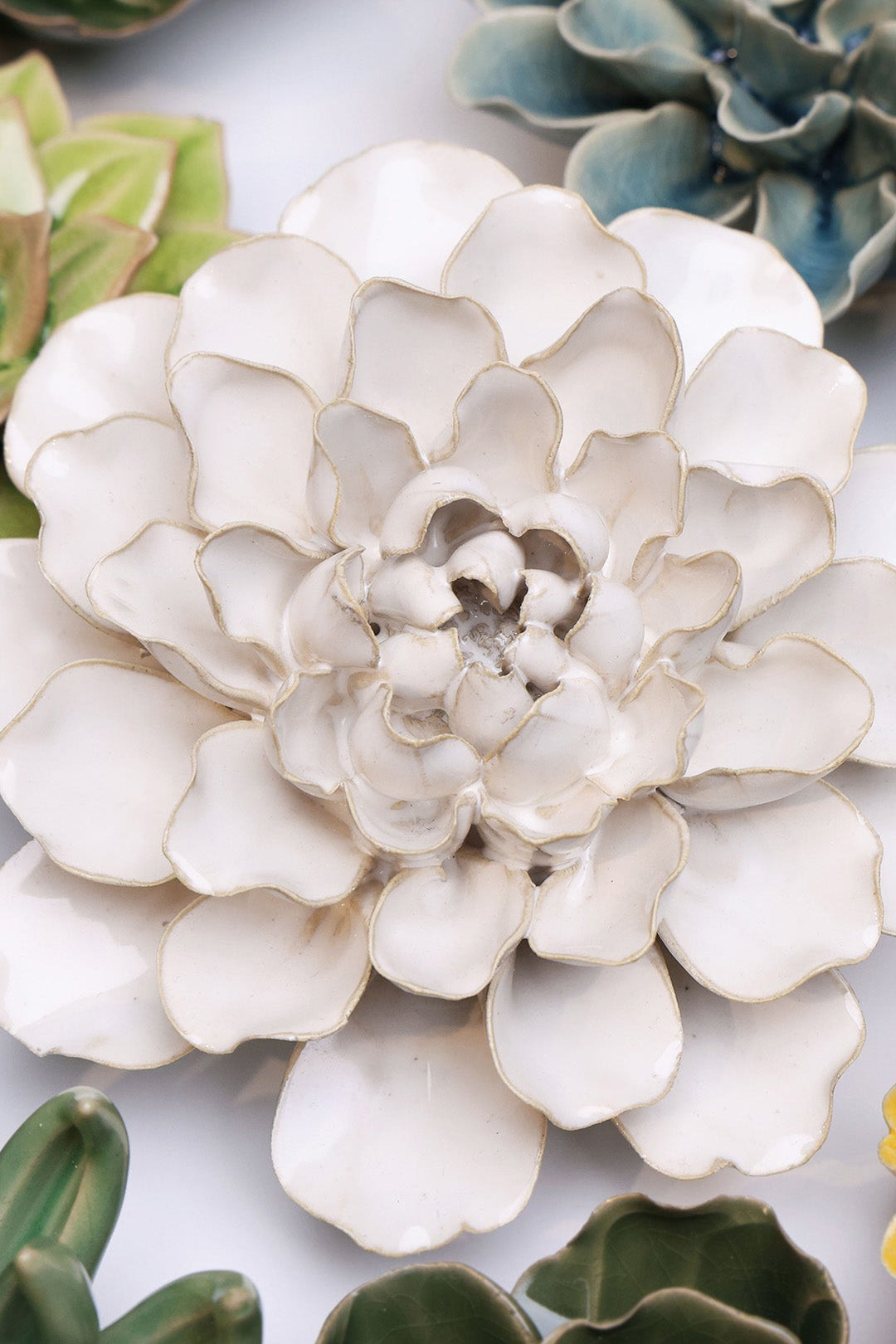 Ivory Water Lily ceramic wall flower styled on a white table with other flowers — Chive Studio