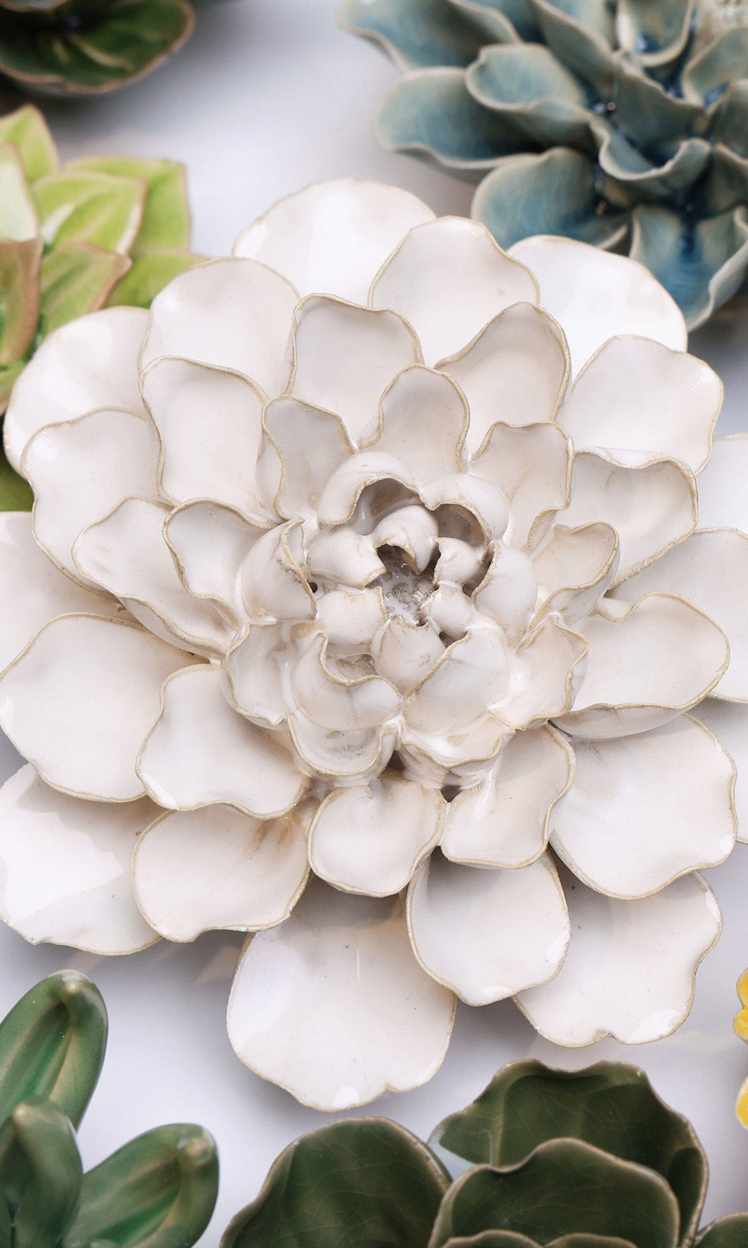 Ivory Water Lily ceramic wall flower styled on a white table with other flowers — Chive Studio