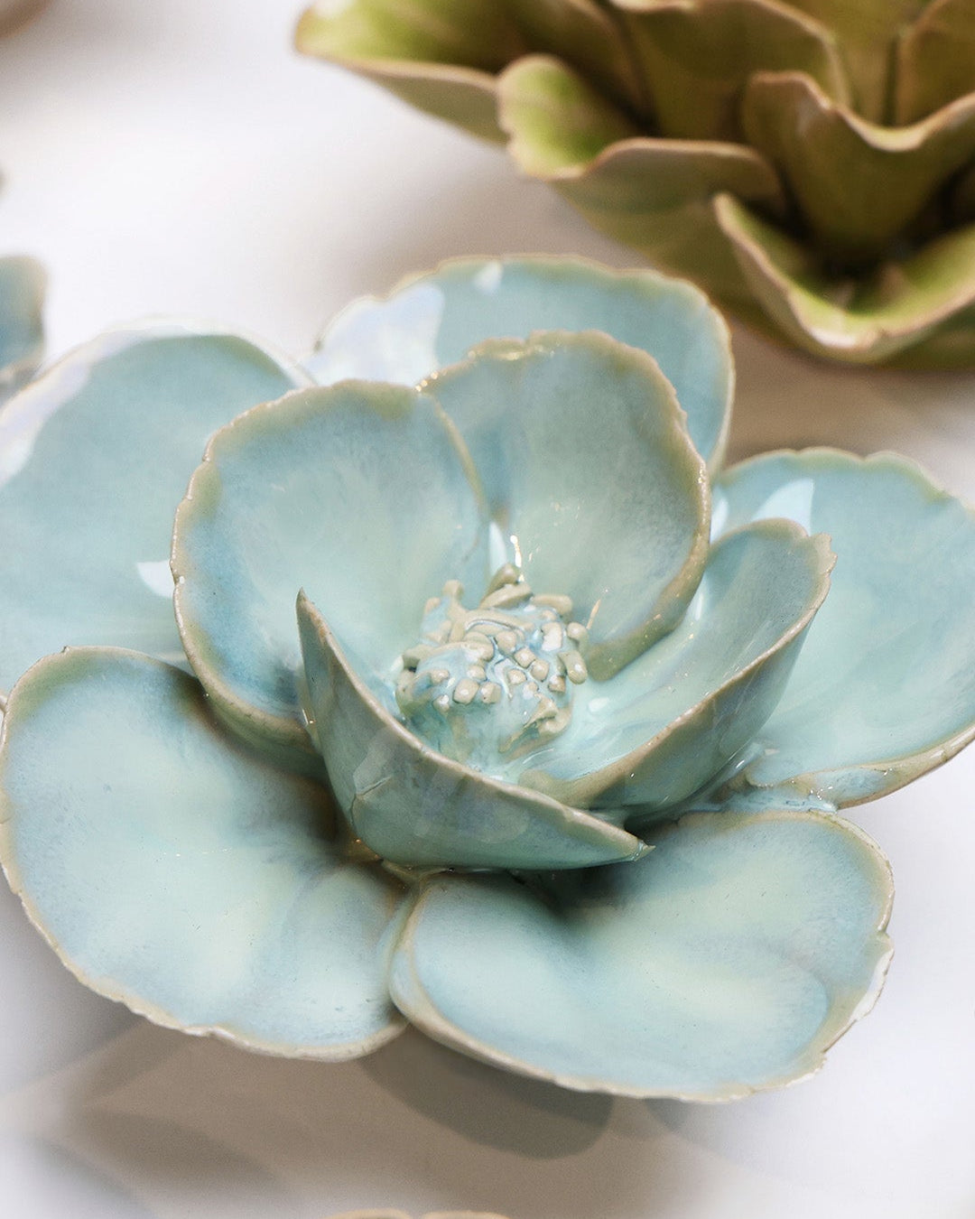 Blue Milk Poppy ceramic wall flower styled on a white table with other flowers — Chive Studio