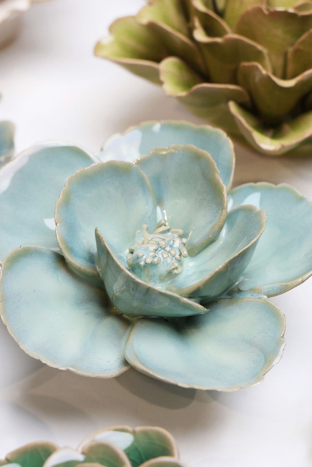 Blue Milk Poppy ceramic wall flower styled on a white table with other flowers — Chive Studio