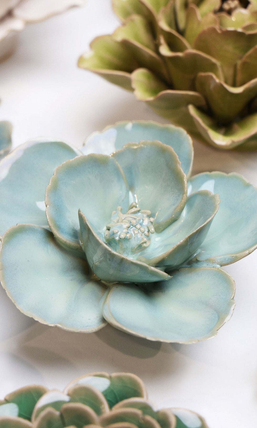 Blue Milk Poppy ceramic wall flower styled on a white table with other flowers — Chive Studio