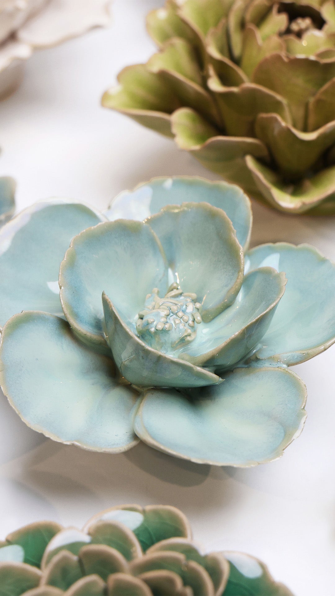 Blue Milk Poppy ceramic wall flower styled on a white table with other flowers — Chive Studio