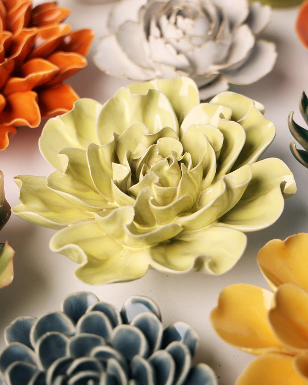 Lime Yellow Larkspur ceramic wall flower mounted on a wall — Chive Ceramics Studio