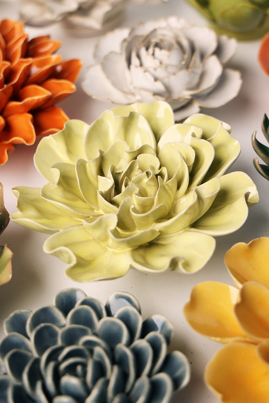 Lime Yellow Yellow Larkspur ceramic wall flower styled on a white table with other flowers — Chive Studio