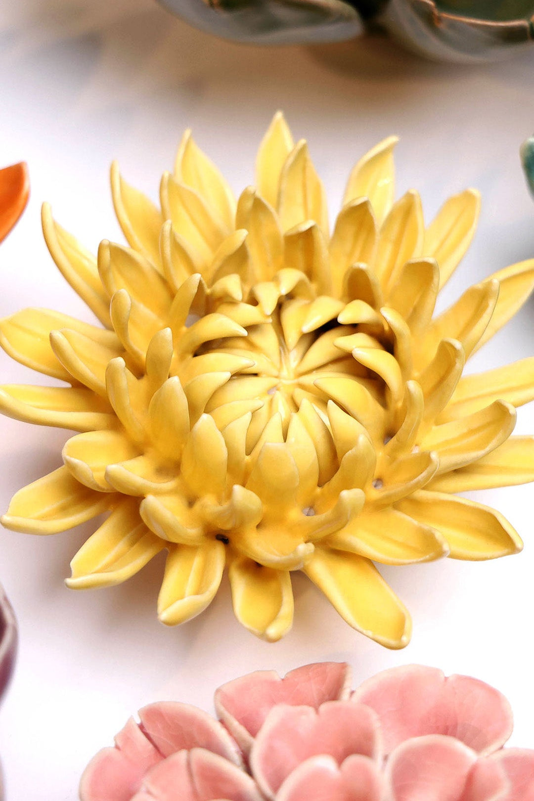 Yellow Sarah Mum ceramic wall flower styled on a white table with other flowers — Chive Studio