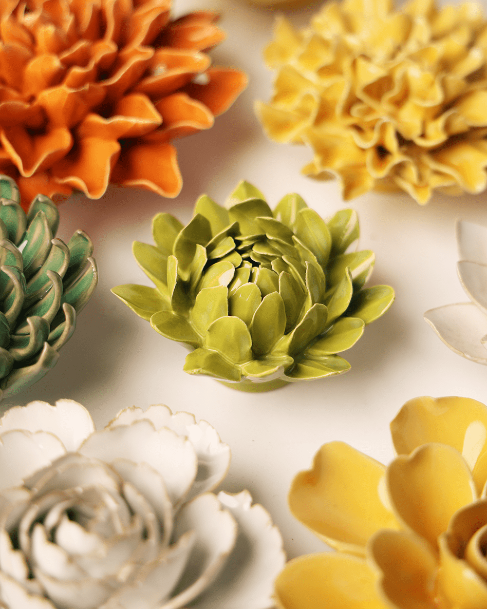 Chartreuse Sugarbush Protea ceramic wall flower mounted on a wall — Chive Ceramics Studio