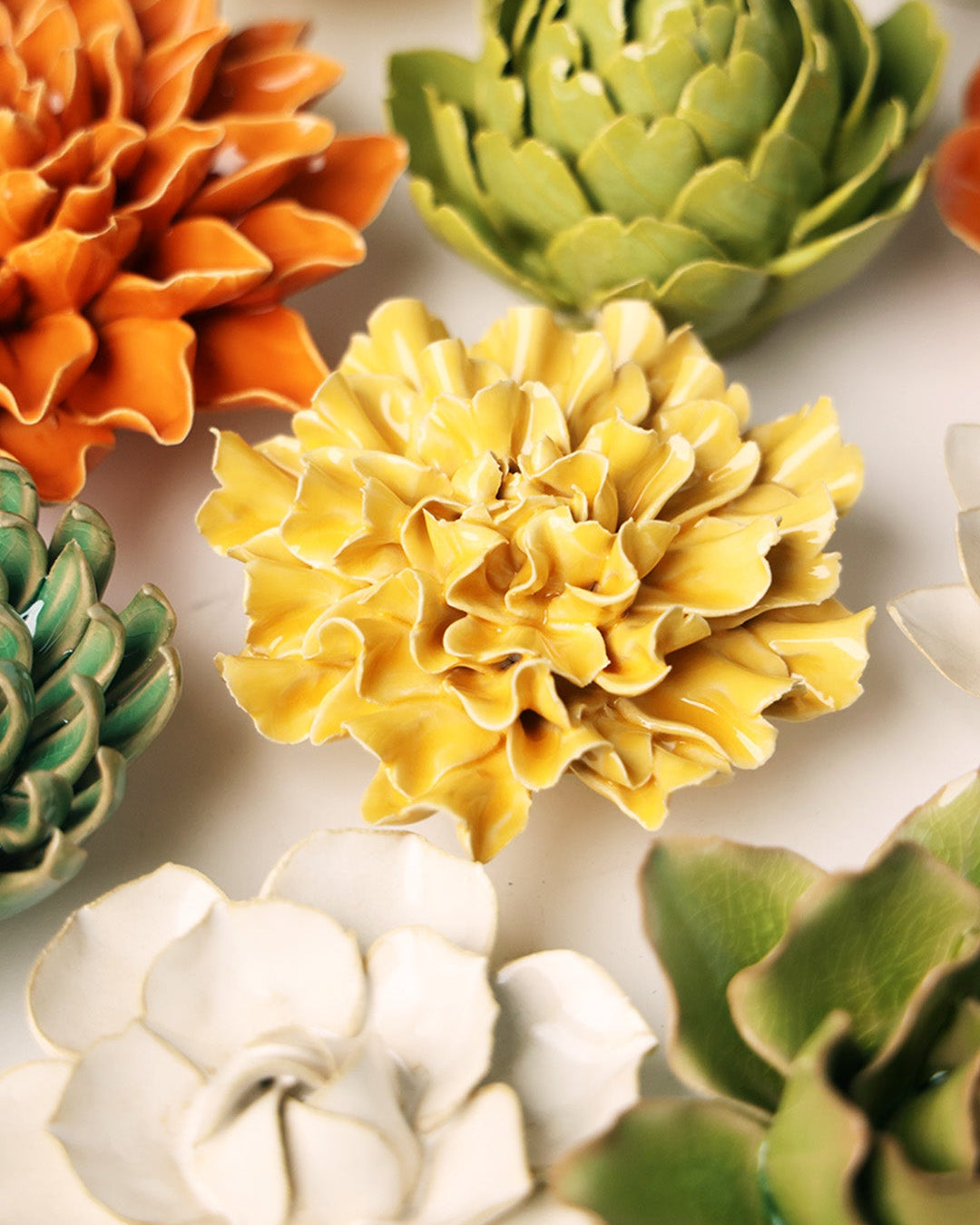 Burnt Yellow Tundra Carnation ceramic wall flower mounted on a wall — Chive Ceramics Studio