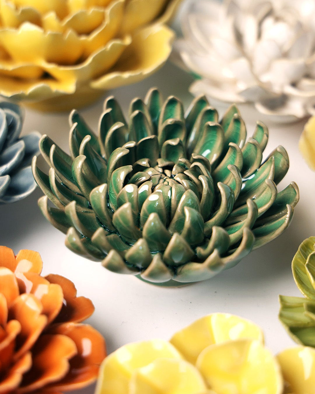 Jungle Green Pompom Mum ceramic wall flower mounted on a wall — Chive Ceramics Studio