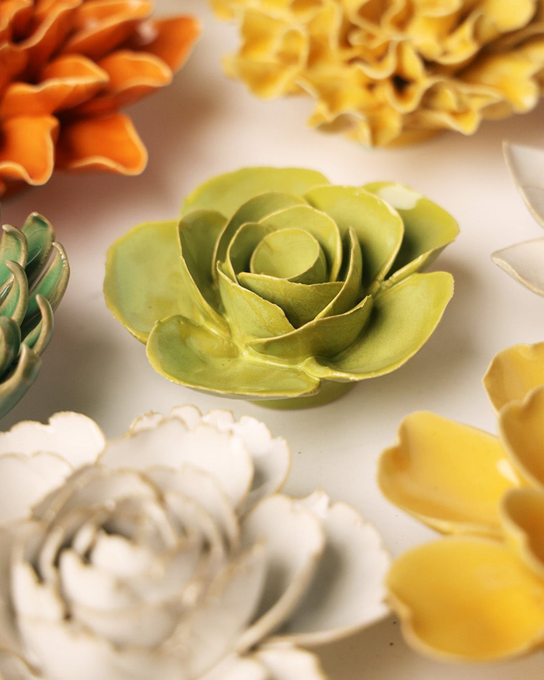 Chartreuse Elegance Ranunculus ceramic wall flower mounted on a wall — Chive Ceramics Studio