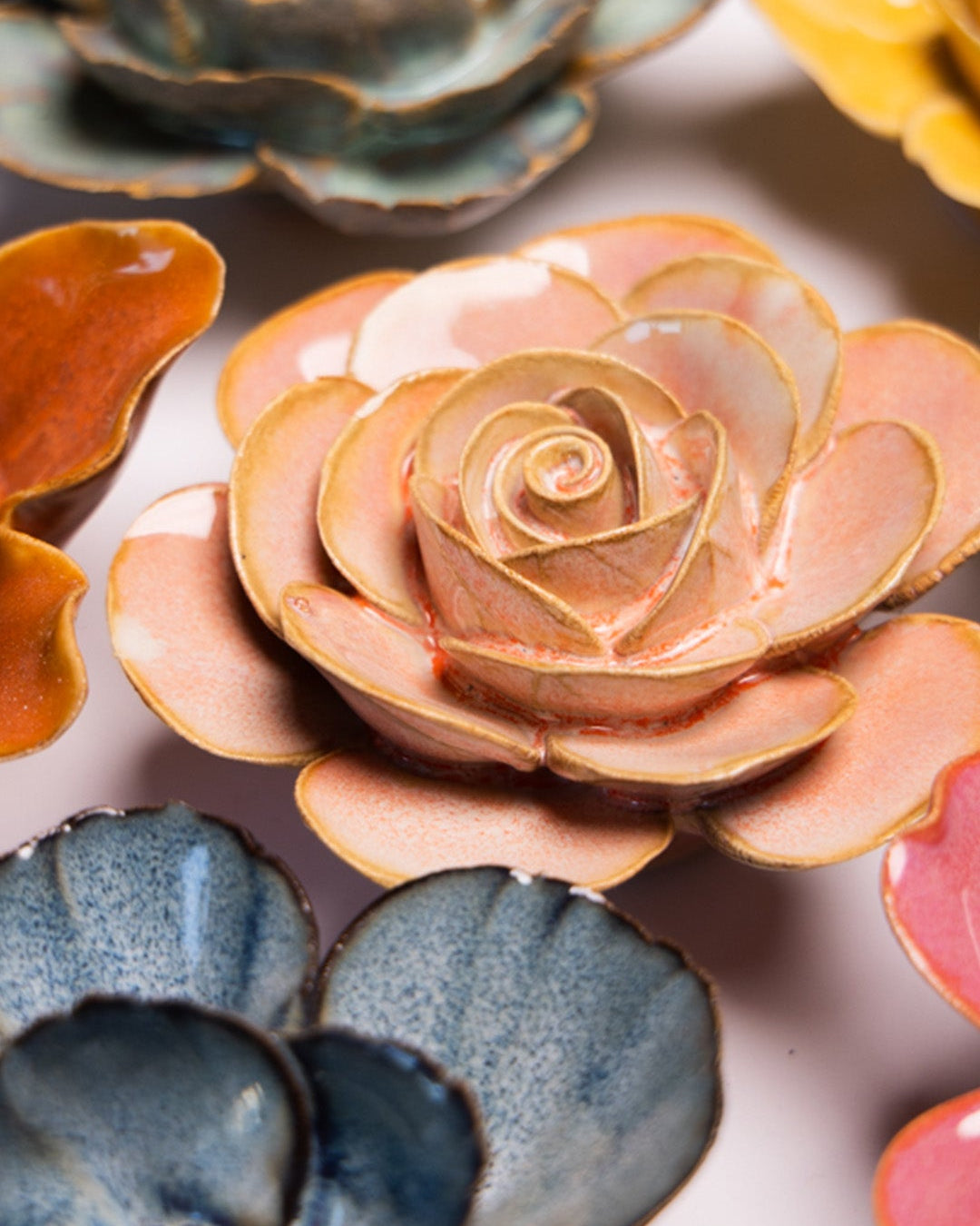 Peach Pink Ranunculus ceramic wall flower styled on a white table with other flowers — Chive Studio