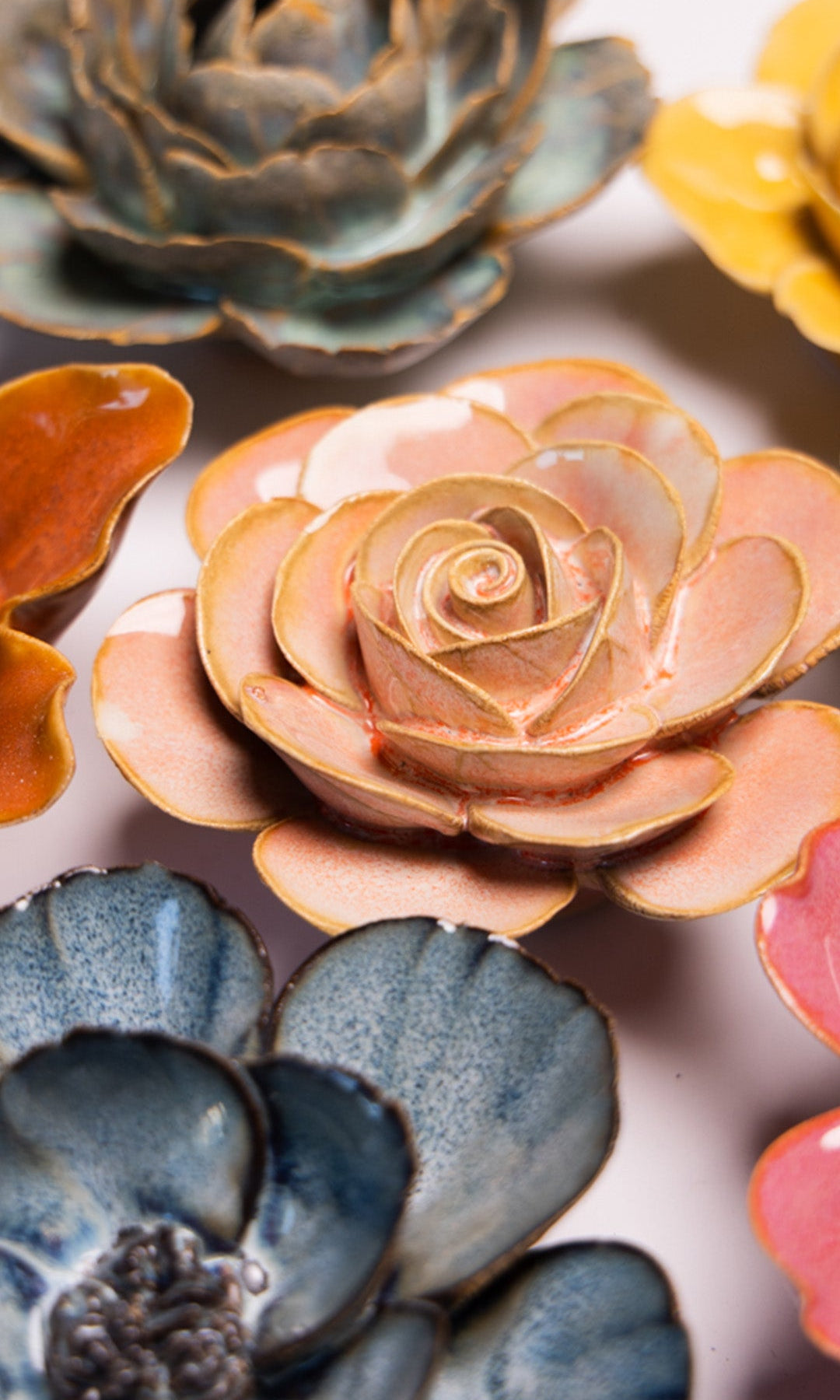 Peach Pink Ranunculus ceramic wall flower styled on a white table with other flowers — Chive Studio