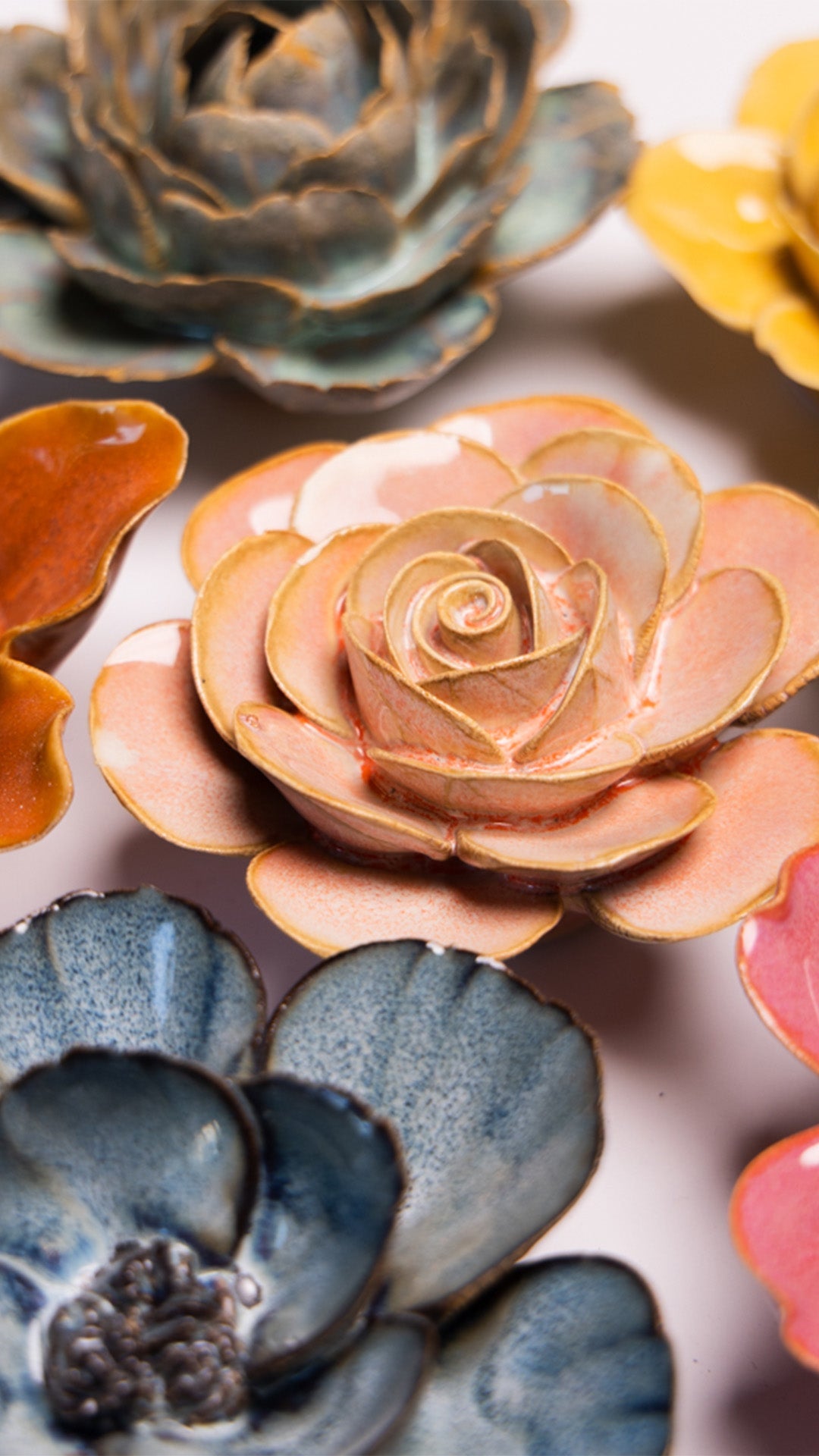 Peach Pink Ranunculus ceramic wall flower styled on a white table with other flowers — Chive Studio