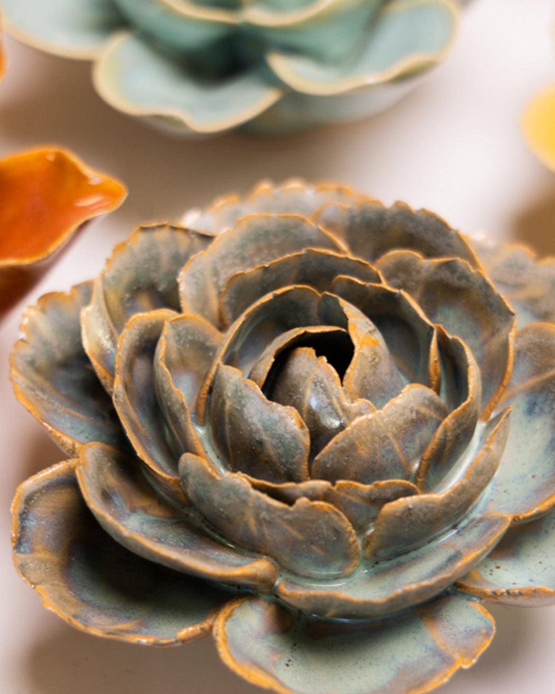 Blue Rose ceramic wall flower styled on a white table with other flowers — Chive Studio