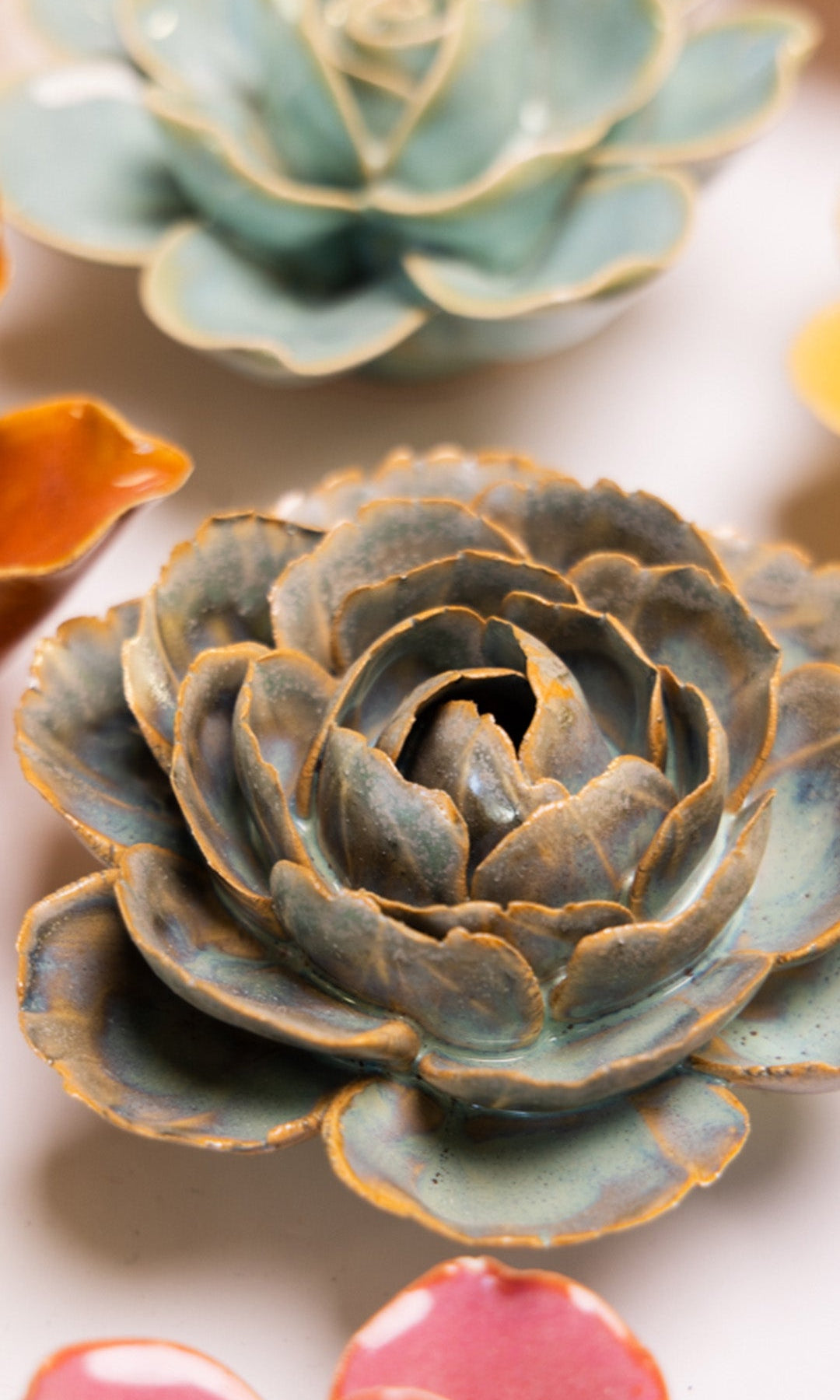 Blue Rose ceramic wall flower styled on a white table with other flowers — Chive Studio