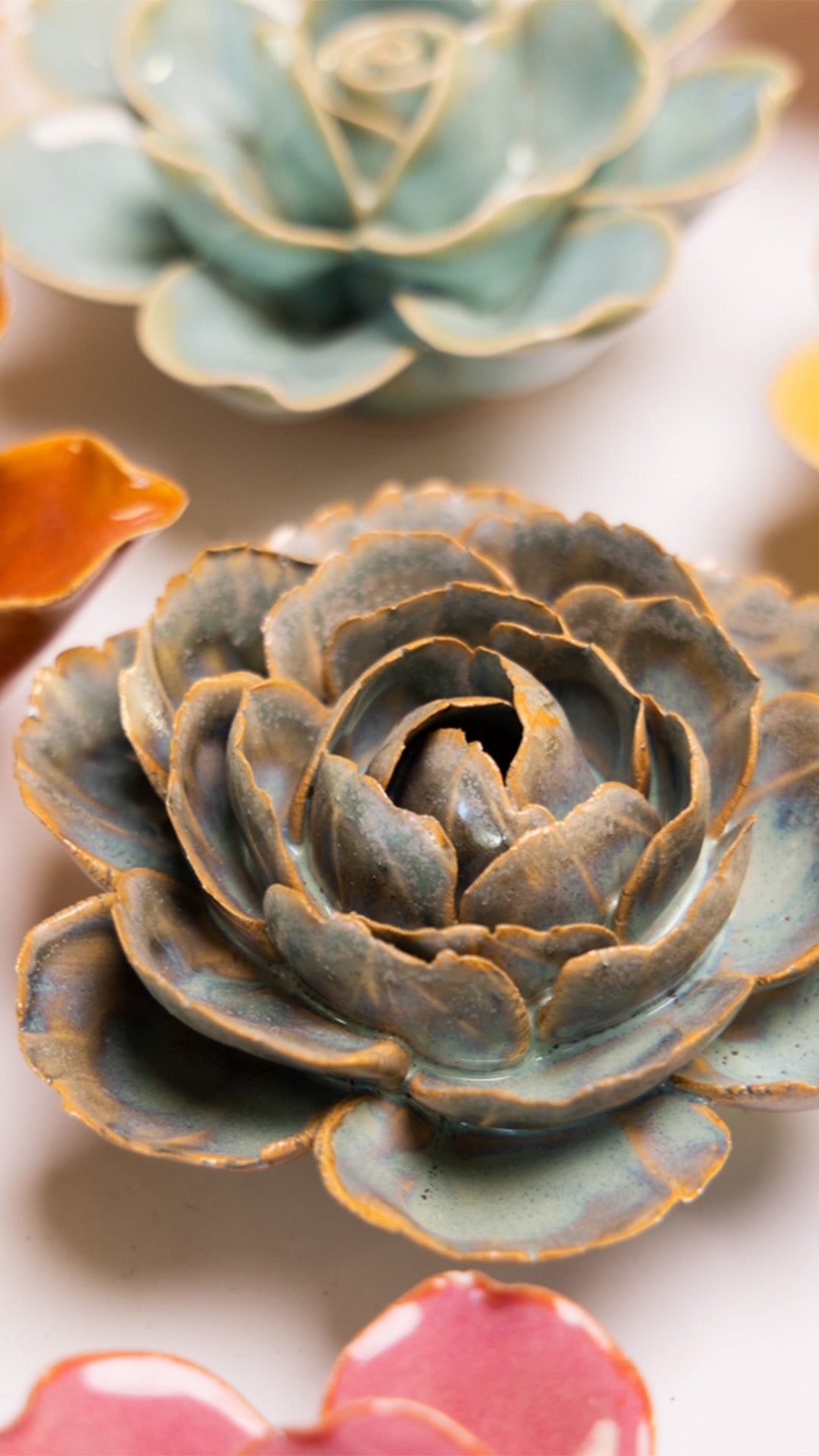 Blue Rose ceramic wall flower styled on a white table with other flowers — Chive Studio