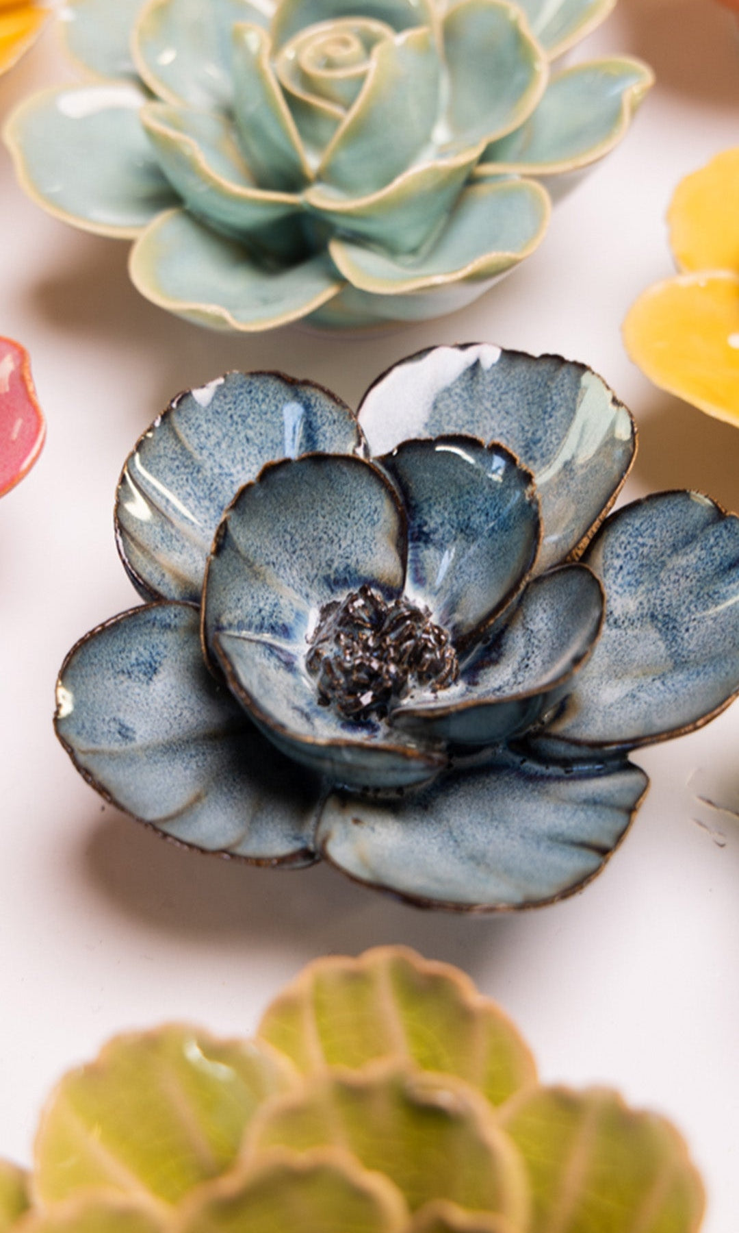 Navy Blue Poppy ceramic wall flower styled on a white table with other flowers — Chive Studio