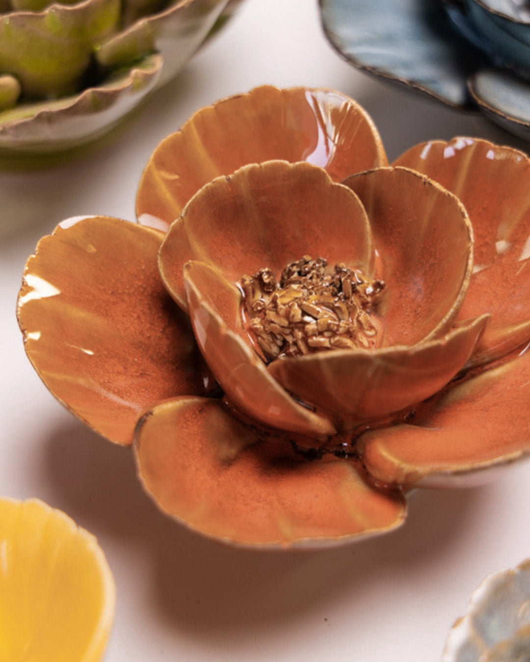 Orange Poppy ceramic wall flower styled on a white table with other flowers — Chive Studio