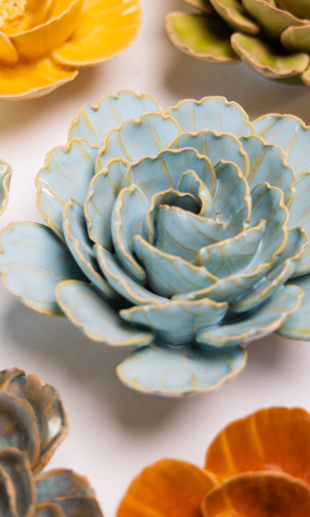 Robin's Egg Blue Keiko Peony ceramic wall flower styled on a white table with other flowers — Chive Studio