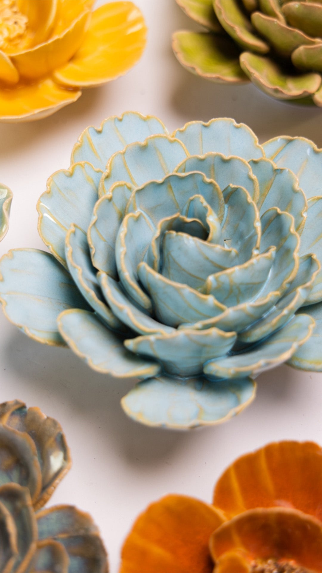 Robin's Egg Blue Keiko Peony ceramic wall flower styled on a white table with other flowers — Chive Studio