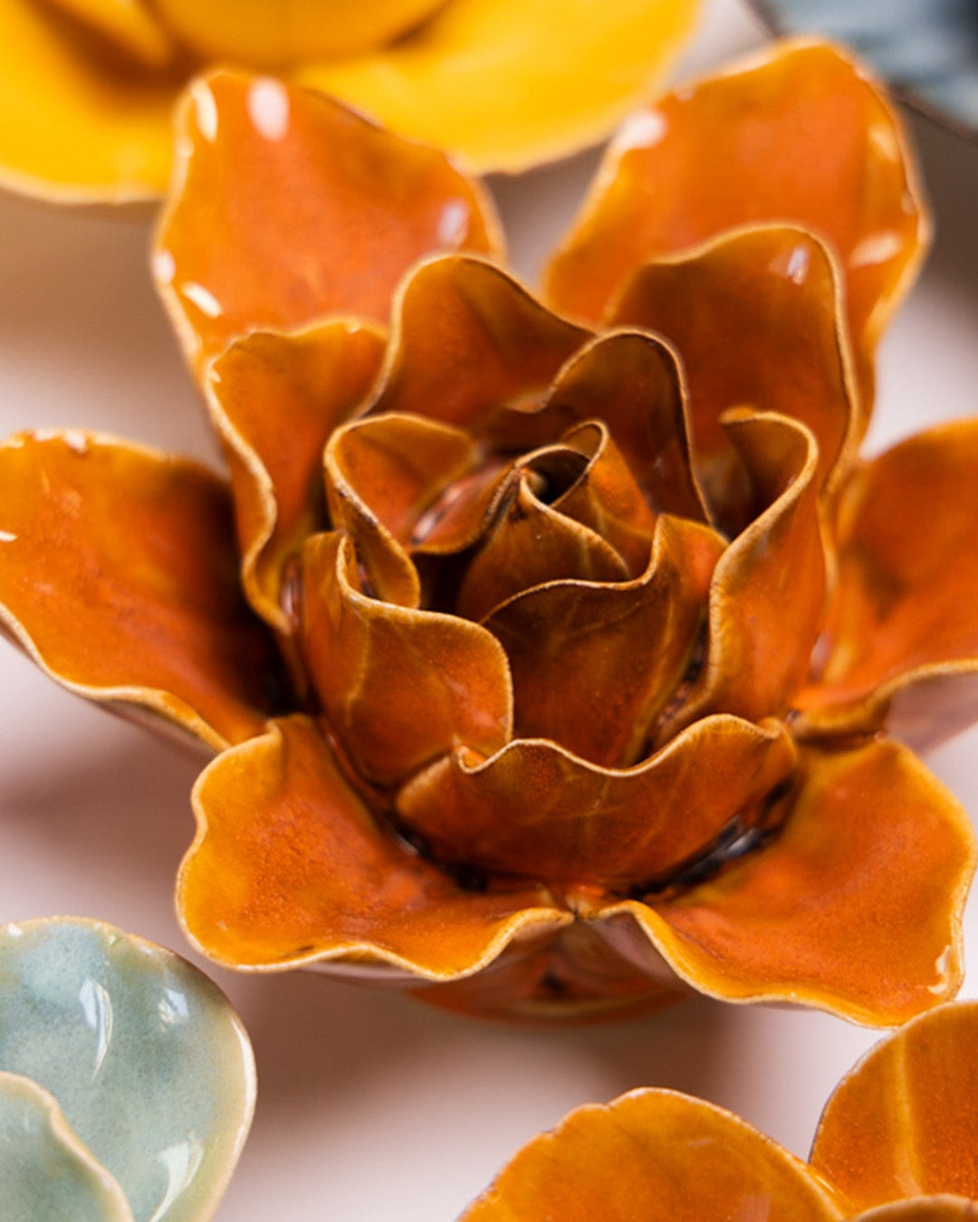 Orange Lily ceramic wall flower styled on a white table with other flowers — Chive Studio