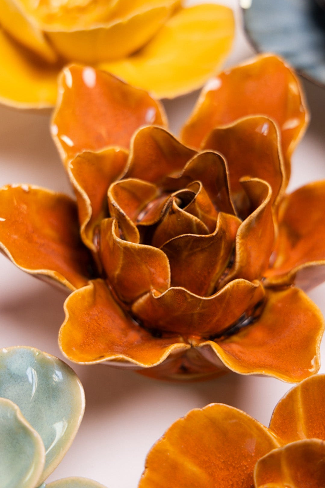 Orange Lily ceramic wall flower styled on a white table with other flowers — Chive Studio