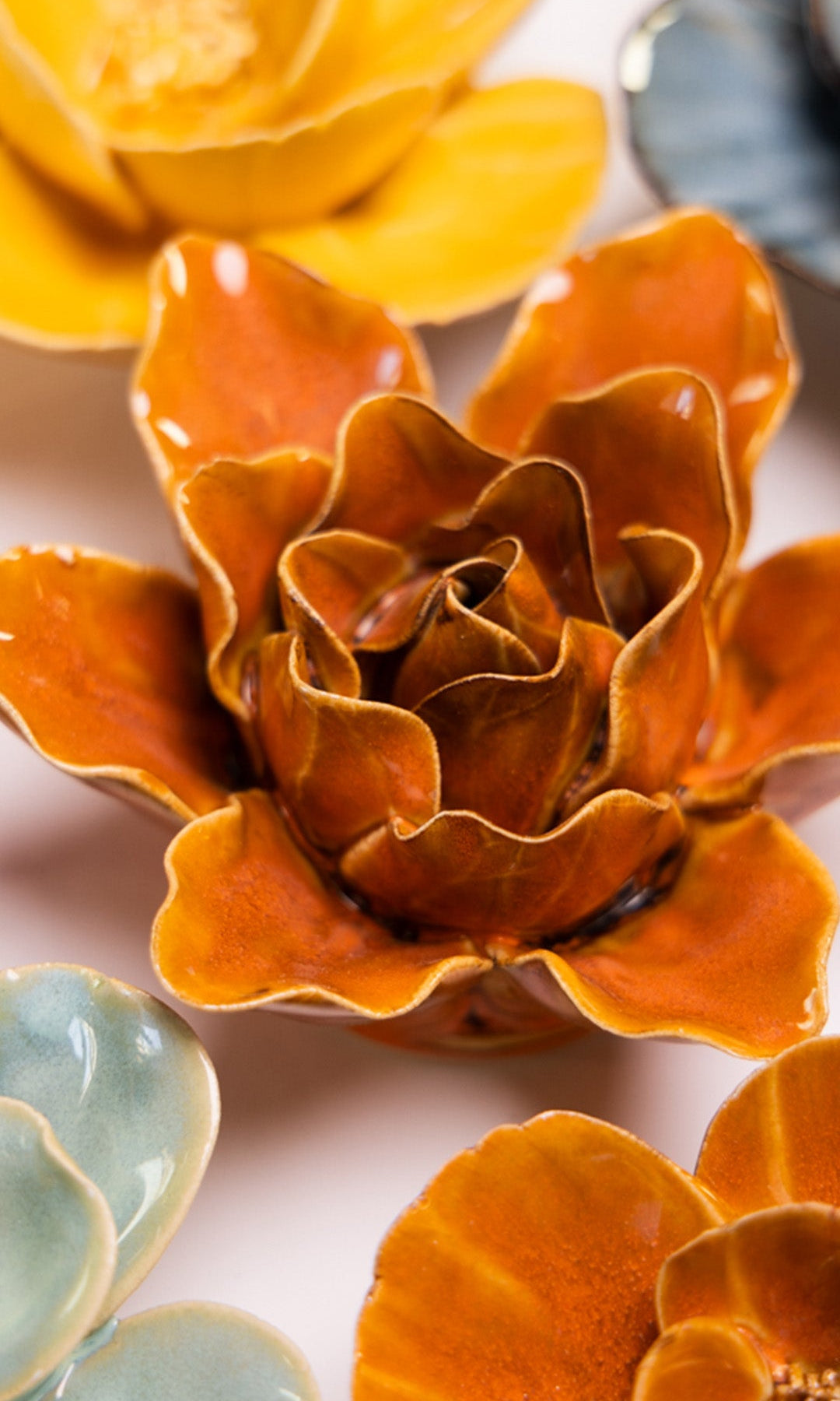 Orange Lily ceramic wall flower styled on a white table with other flowers — Chive Studio