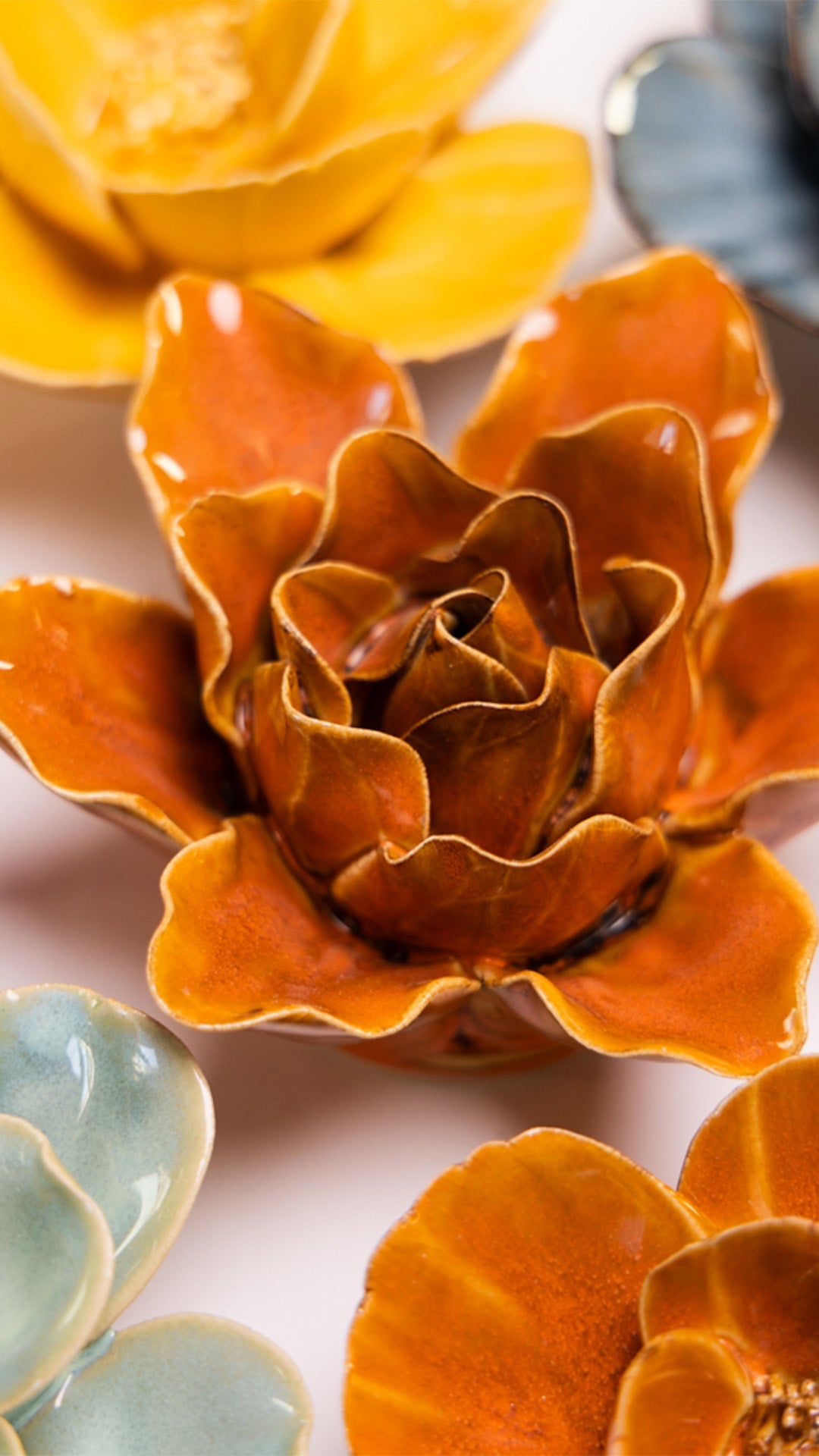 Orange Lily ceramic wall flower styled on a white table with other flowers — Chive Studio