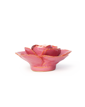 A small pink ceramic flower-shaped dish with gold-painted edges, photographed on a clean white background.