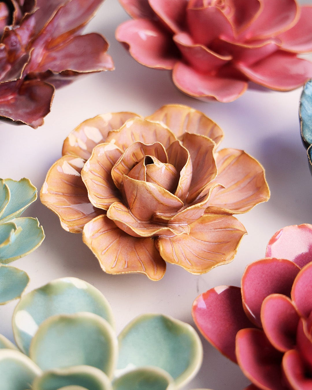 Peach Pink Solar Carnation ceramic wall flower mounted on a wall — Chive Ceramics Studio