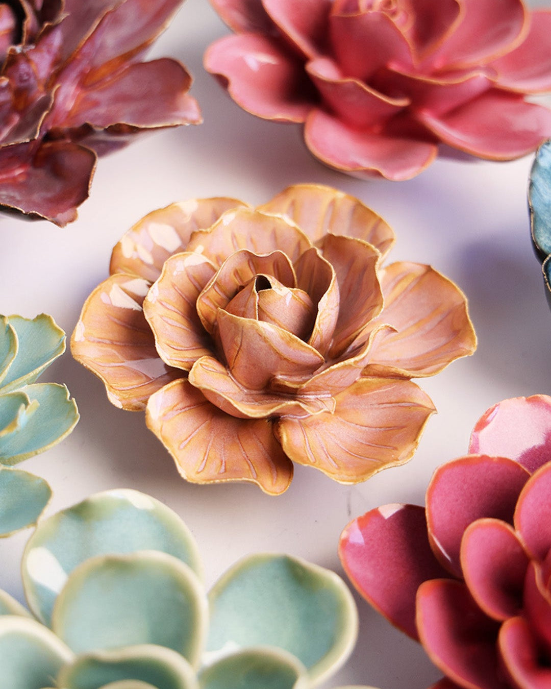 Peach Pink Solar Carnation ceramic wall flower mounted on a wall — Chive Ceramics Studio