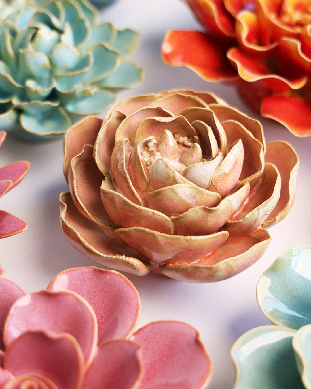 Peach Pink Peony ceramic wall flower styled on a white table with other flowers — Chive Studio