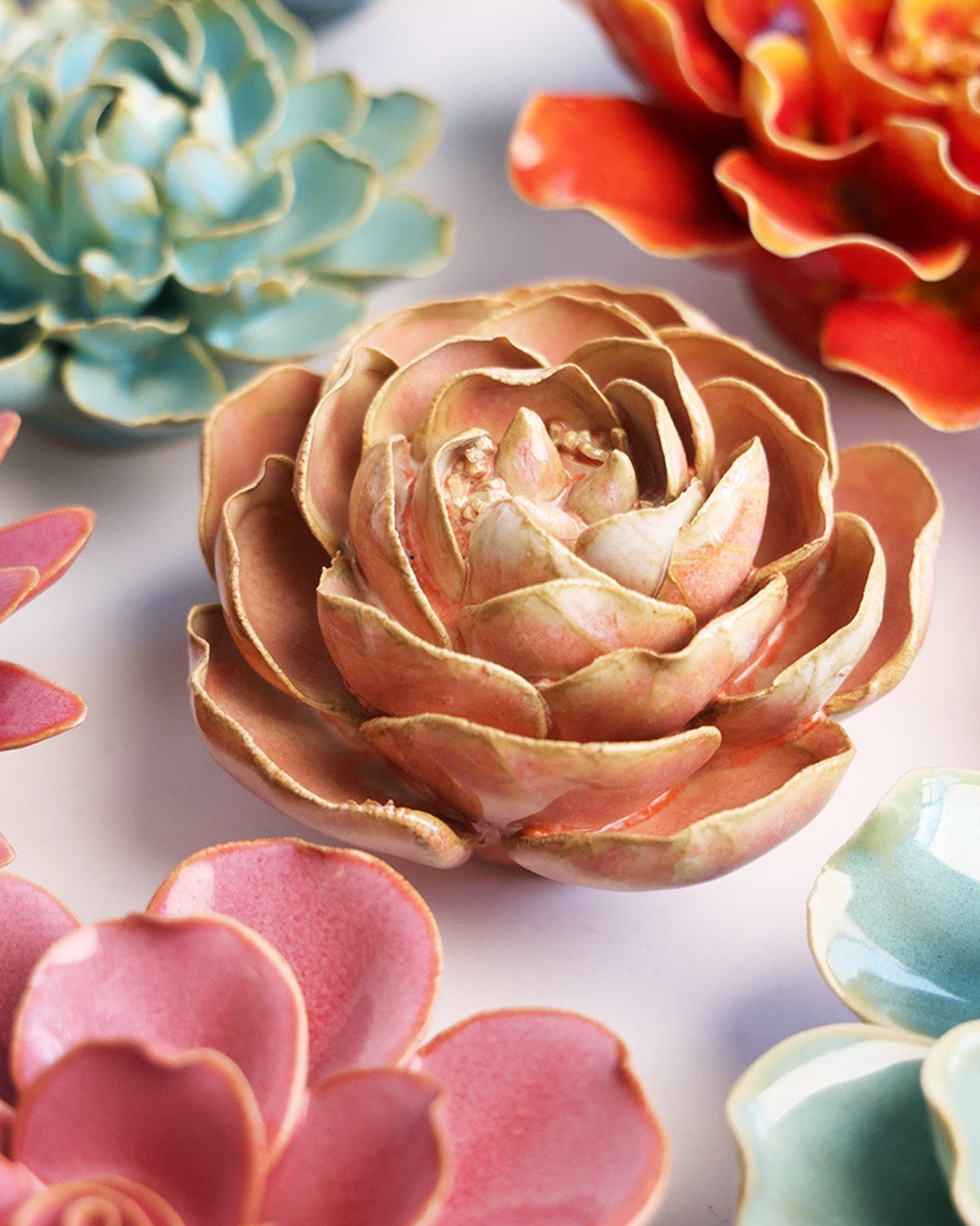Peach Pink Peony ceramic wall flower styled on a white table with other flowers — Chive Studio
