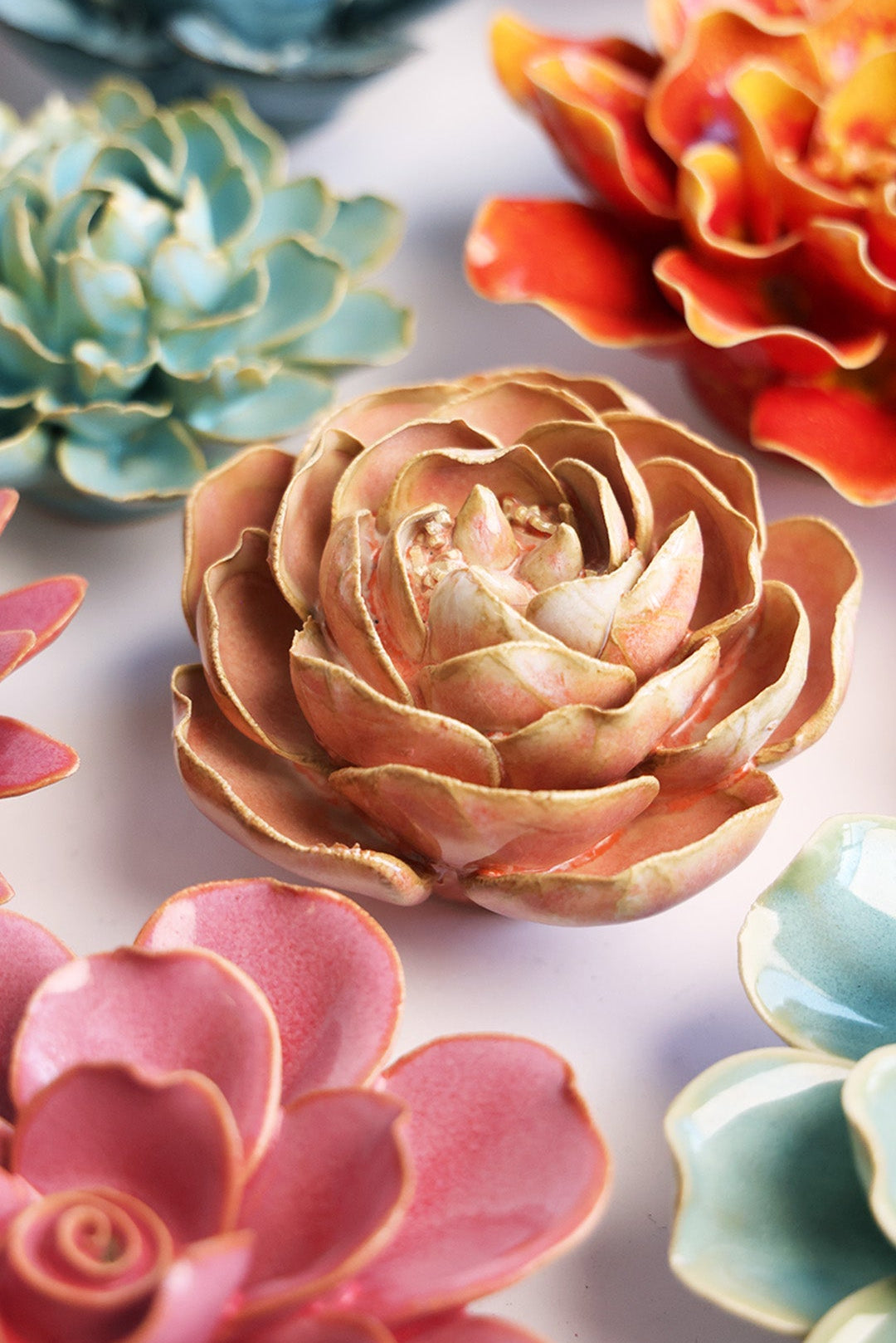 Peach Pink Peony ceramic wall flower styled on a white table with other flowers — Chive Studio