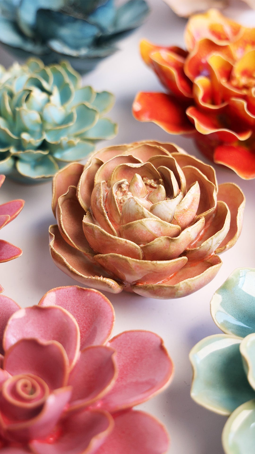 Peach Pink Peony ceramic wall flower styled on a white table with other flowers — Chive Studio
