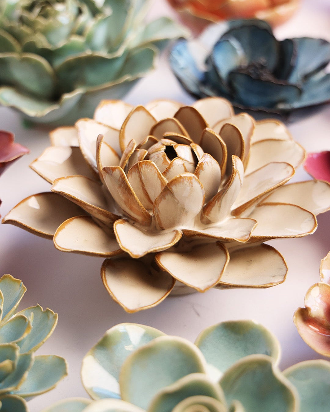Oatmeal Water Lily ceramic wall flower styled on a white table with other flowers — Chive Studio